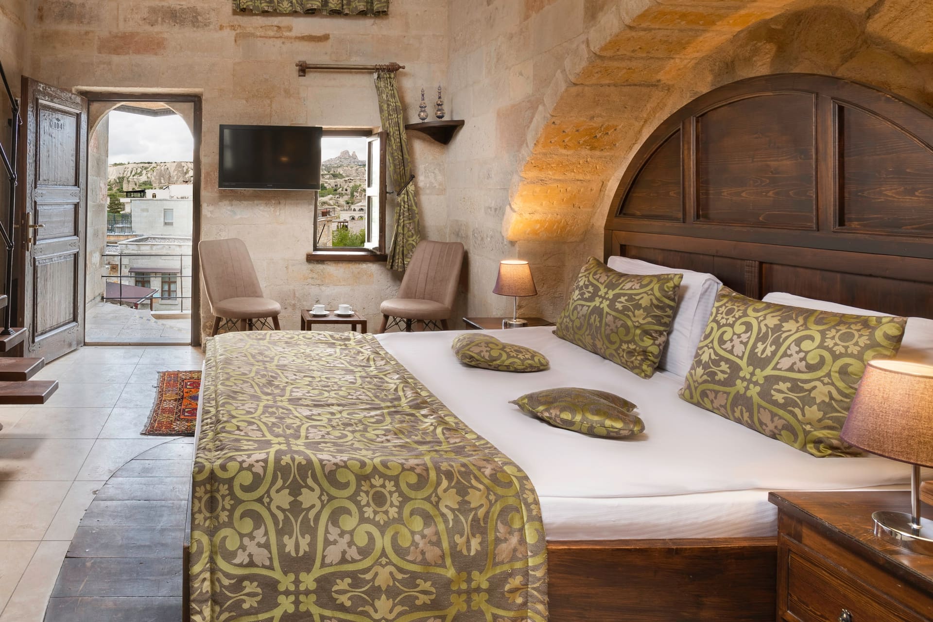 Room 104, Junior Suite: View through open door, patterned bedspread, wood-beamed ceiling.