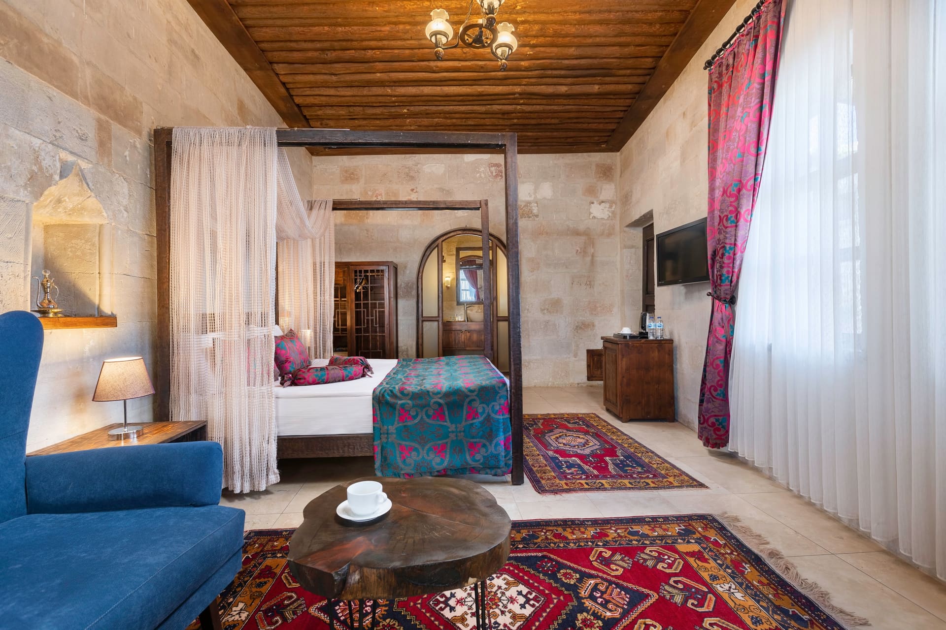 Room 102, Junior Suite: Seating corner, blue sofa, round table, two chairs, rugs.