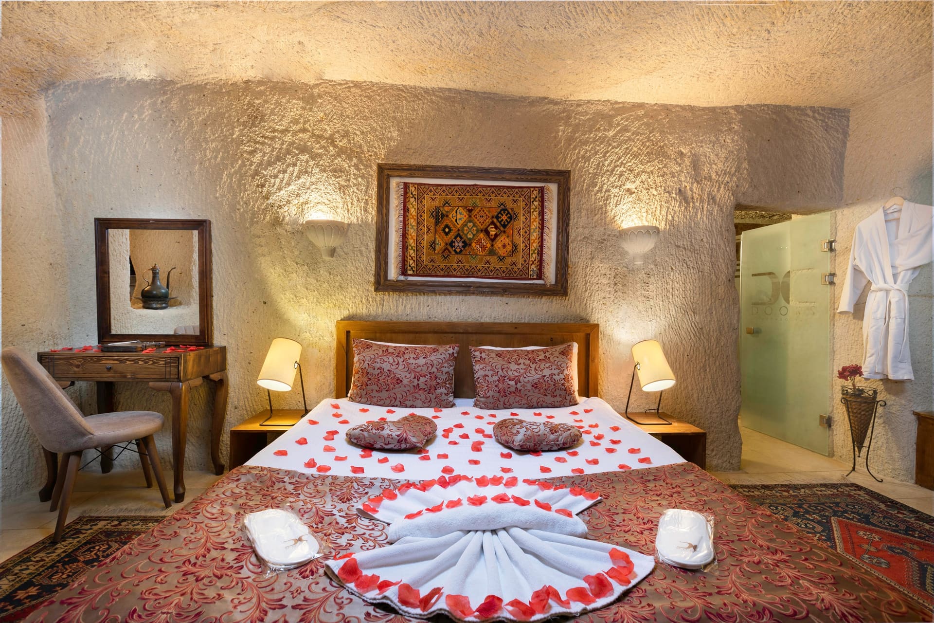 Room 111, King Cave Suite: a wider angle showing the whole bedroom, the terrace door, and a console table