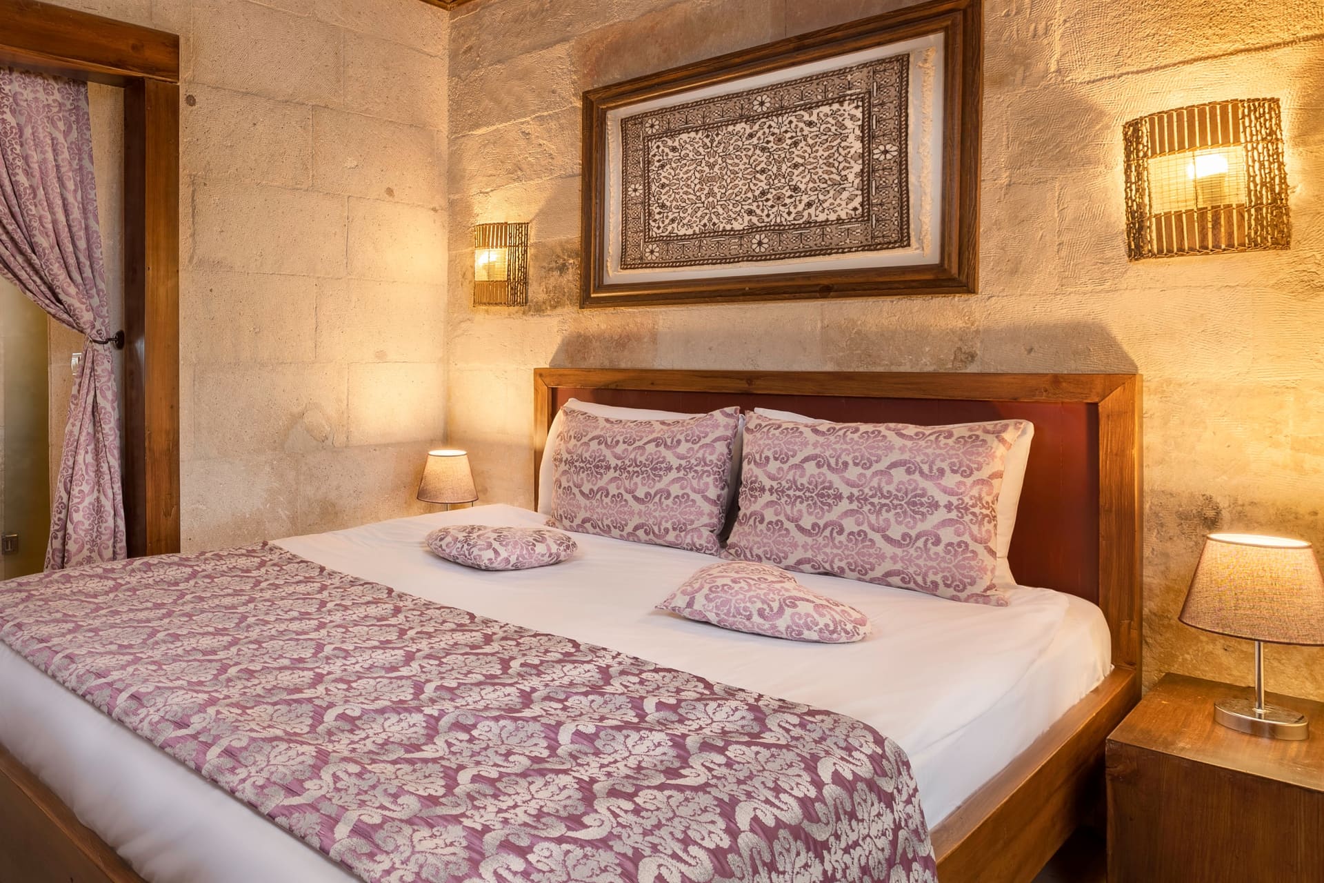 Room 105, King Suite: the headboard with a framed wall panel and sconces on either side