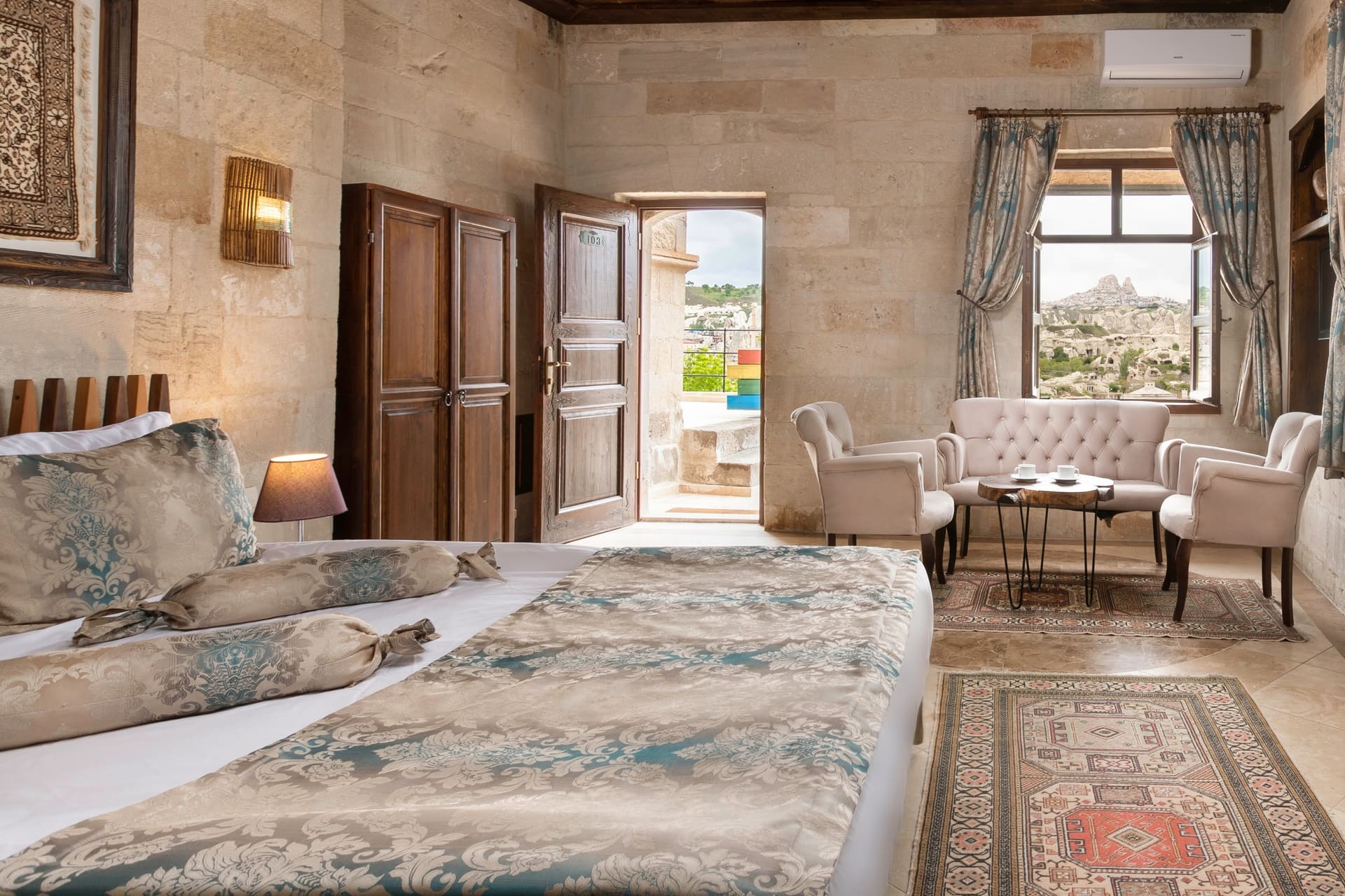 Room 103, Deluxe: Bed, arched passage and armchairs, window