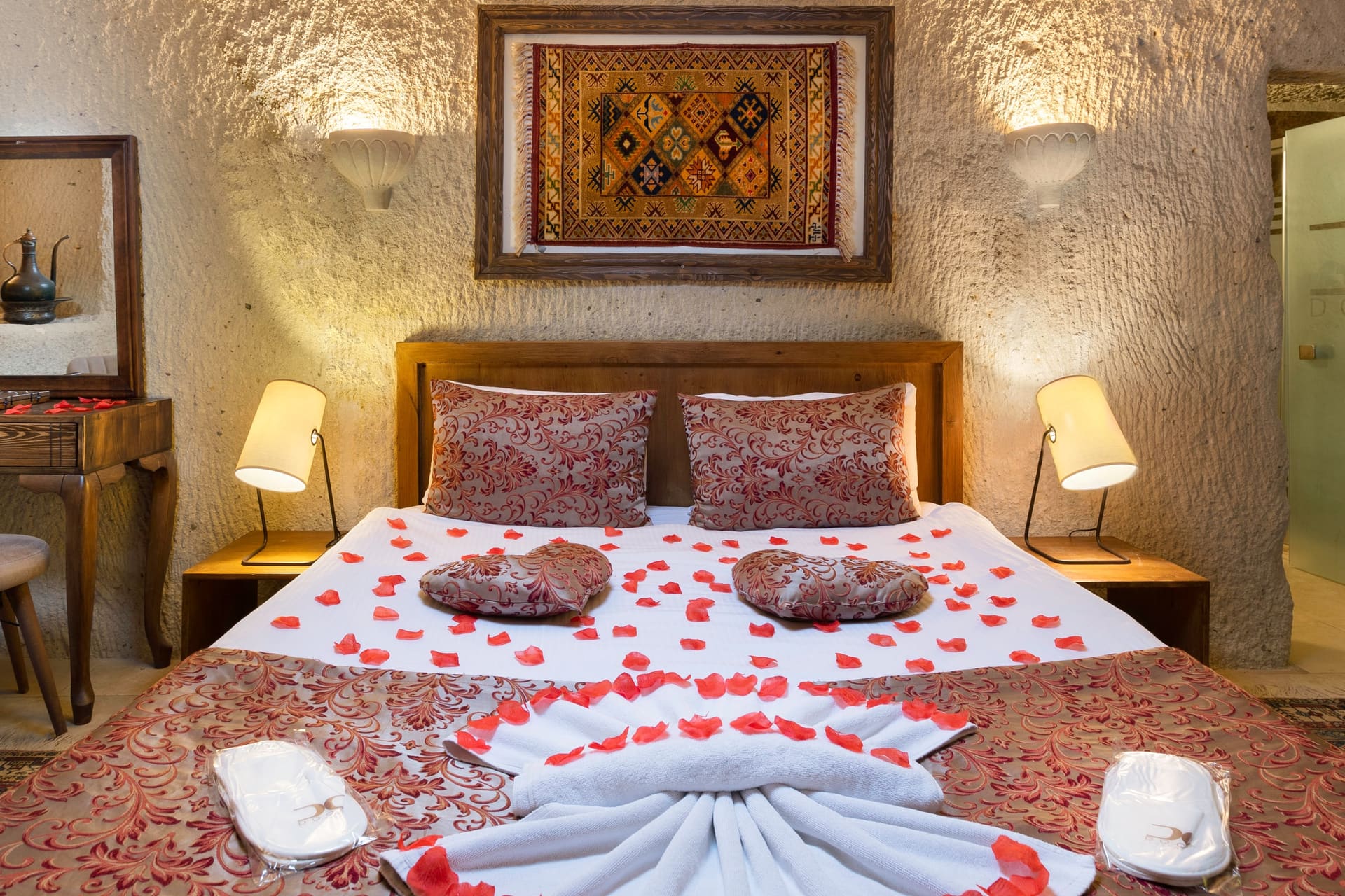 Room 111, King Cave Suite: a closer view of the same bed, a robe hanging visible at the right edge