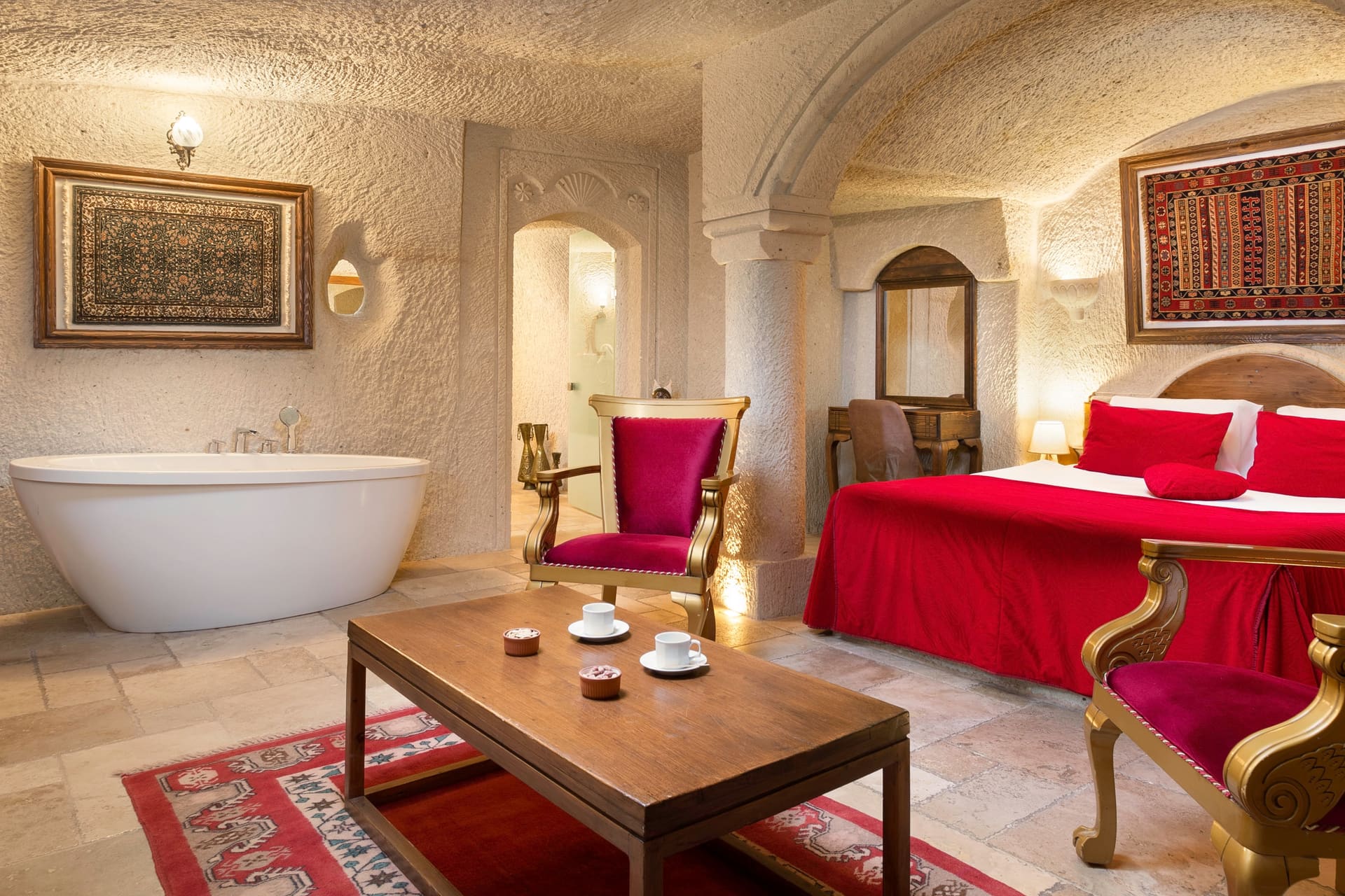Room 115, Junior Cave Suite: bathtub in the corner, burgundy chairs, patterned rug, bed