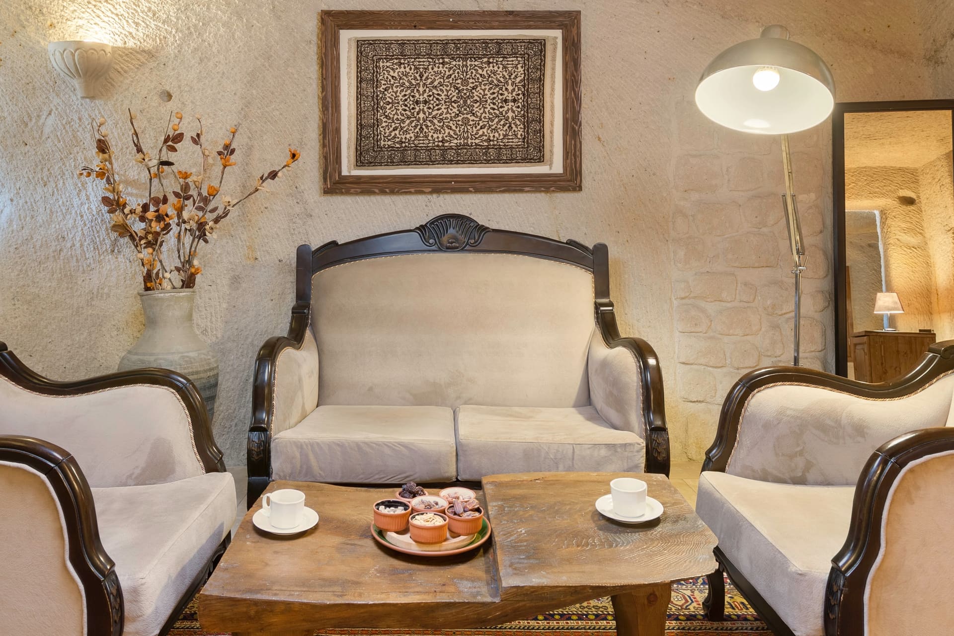 Room 112, King Cave Suite: a closer view of the same seating area, a dried-flower vase and a floor lamp