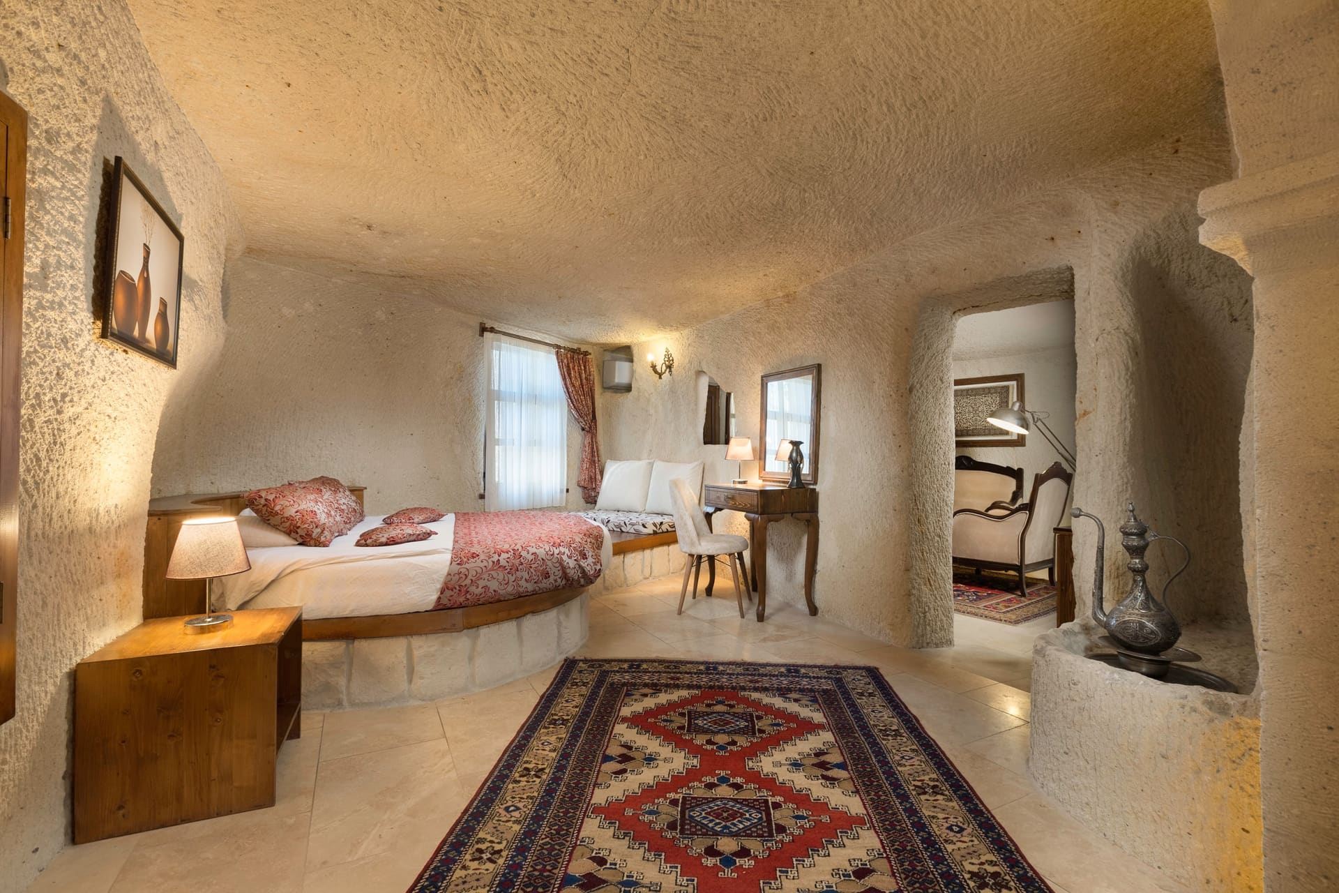 Room 112, King Cave Suite: close view of the bed, the jacuzzi niche behind it, and the corridor to the lounge