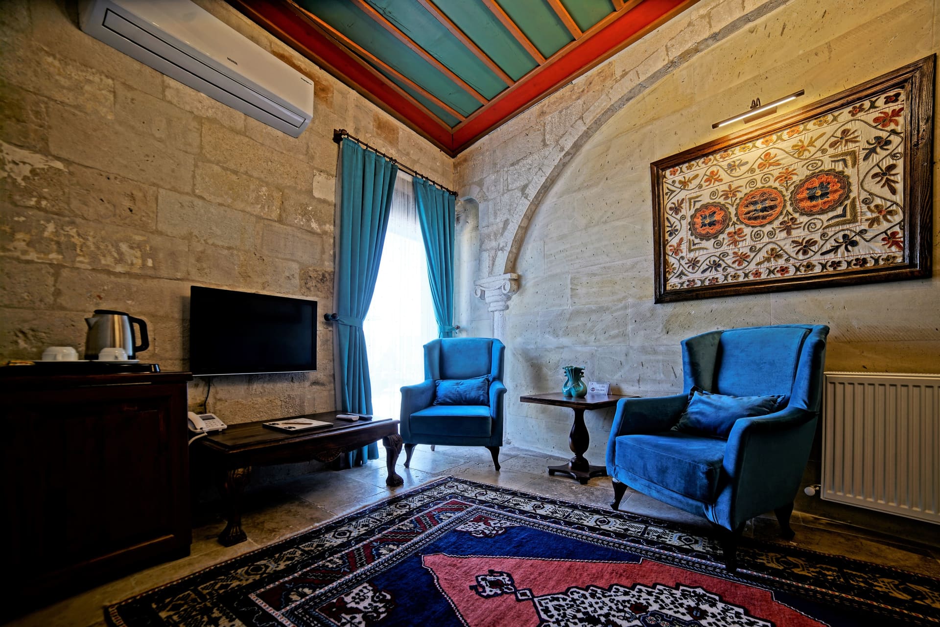 Room 119, Junior Suite: Seating corner, blue armchairs, round table, painted ceiling border.