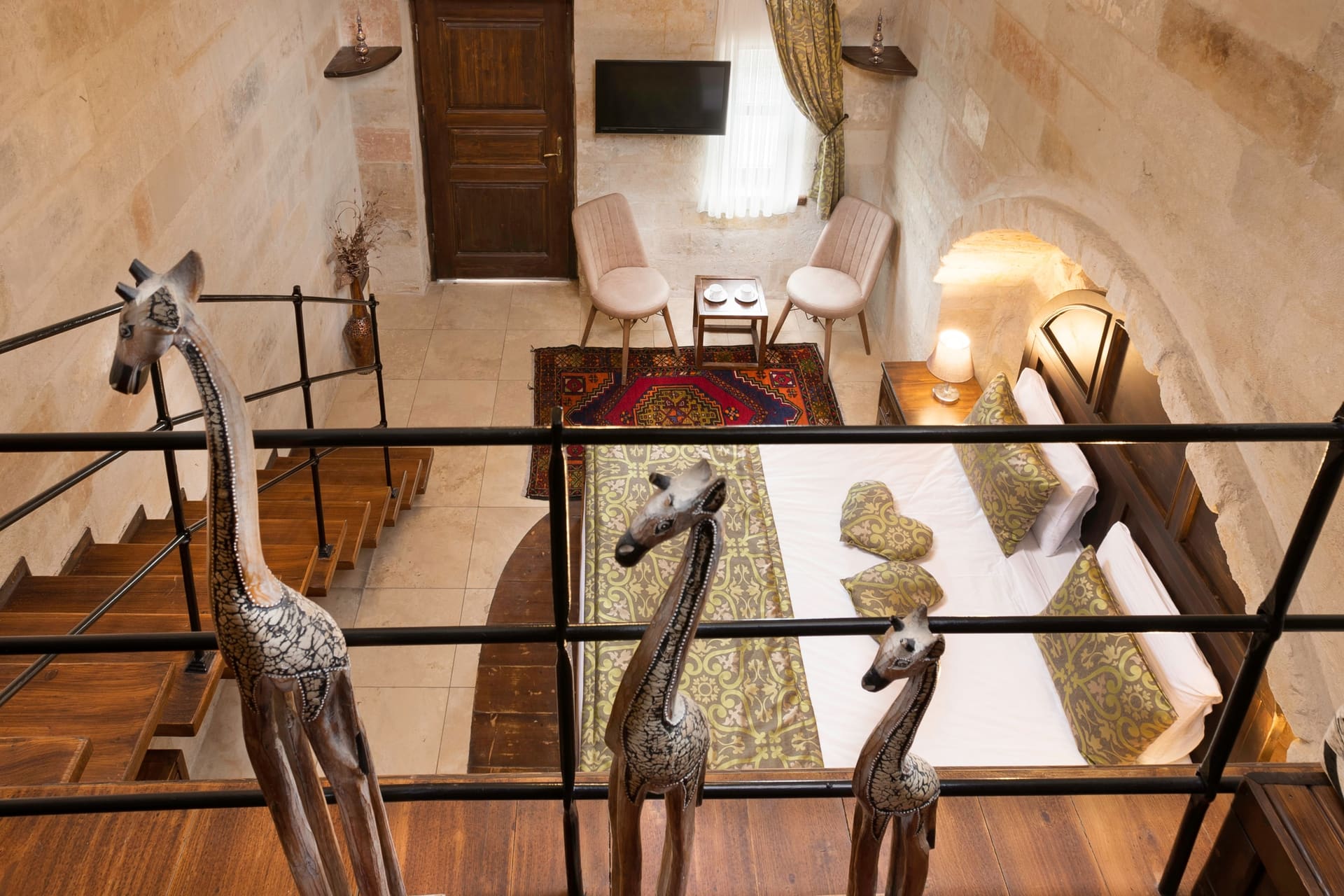 Room 104, Junior Suite: Close-up of mezzanine loft, giraffe figures, railing, desk lamp.