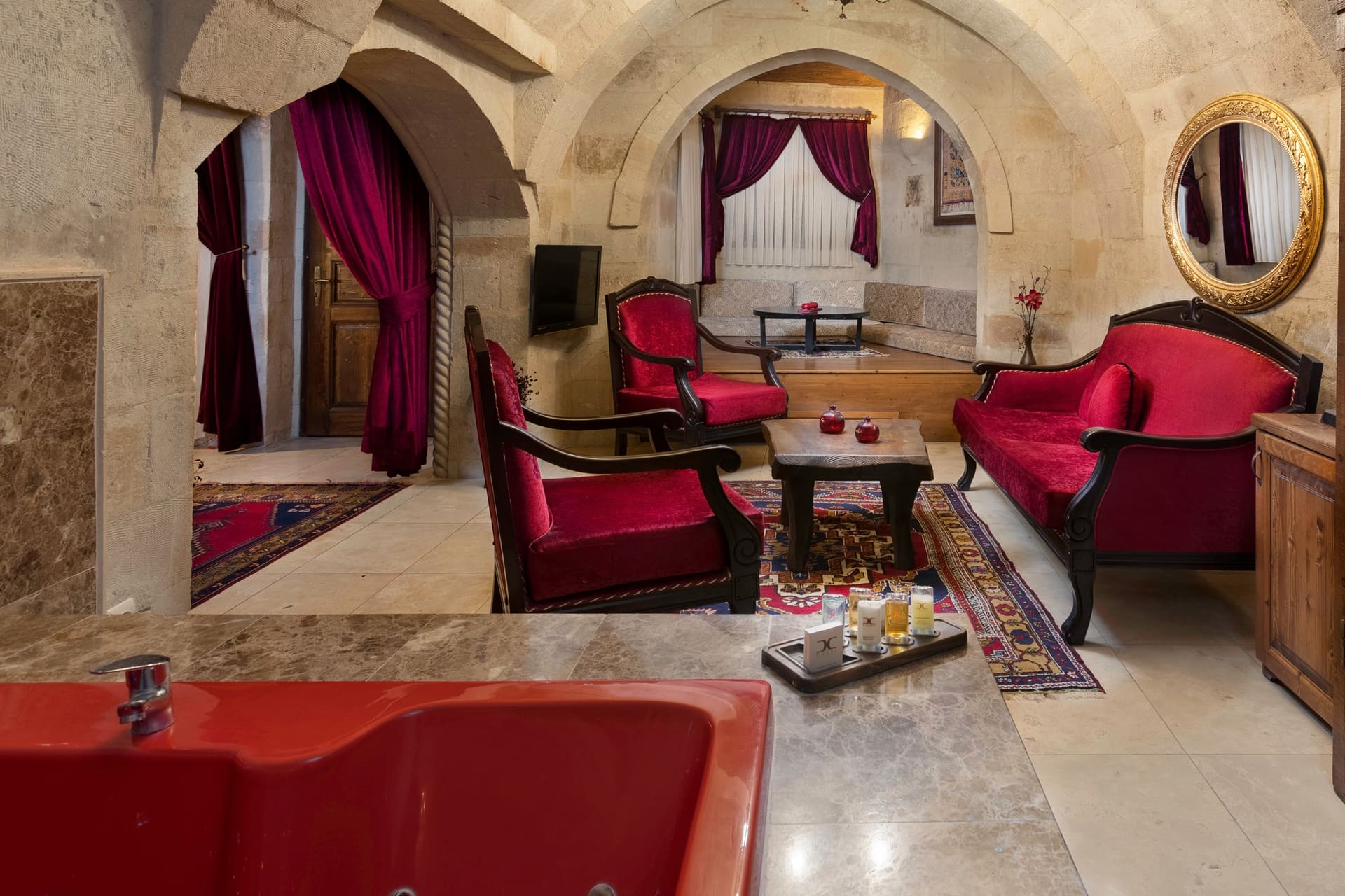 Room 110, Queen Suite: The sitting corner with the edge of the red bathtub in the foreground.