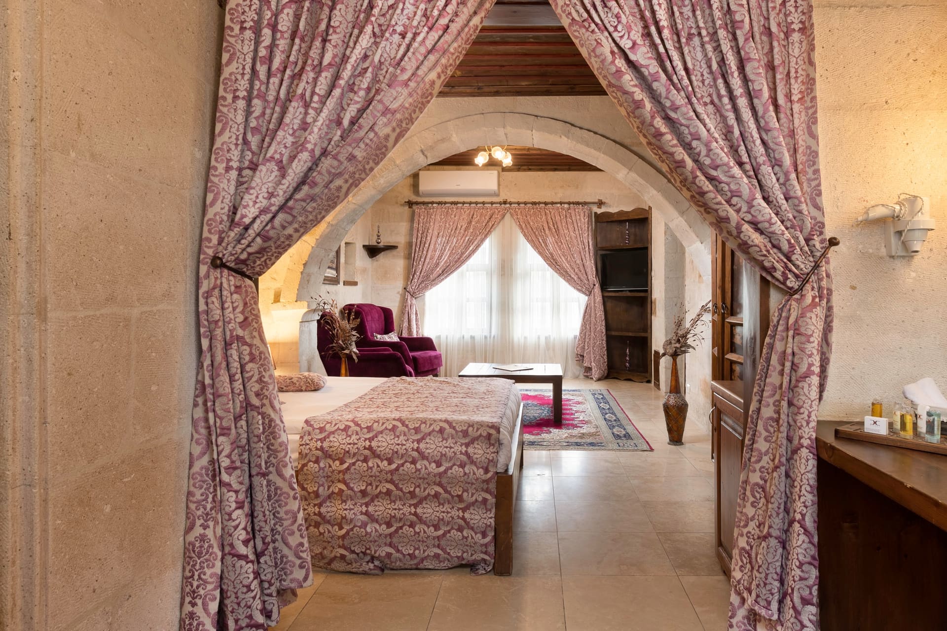 Room 105, King Suite: view through the arch showing the bed and armchair beyond