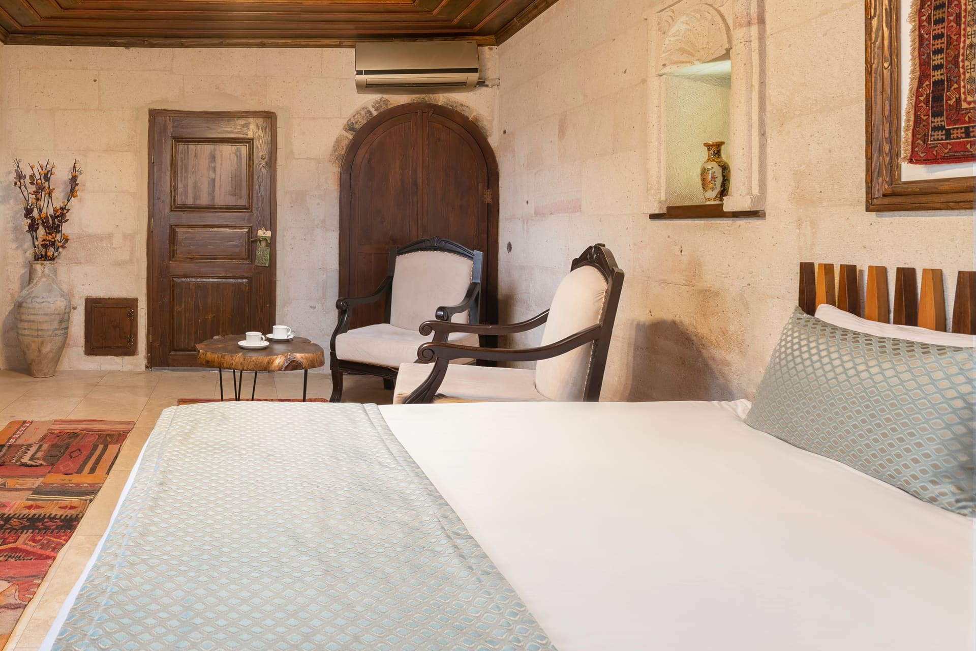 Room 116, Deluxe: Bed, armchairs and arched doorway, vase