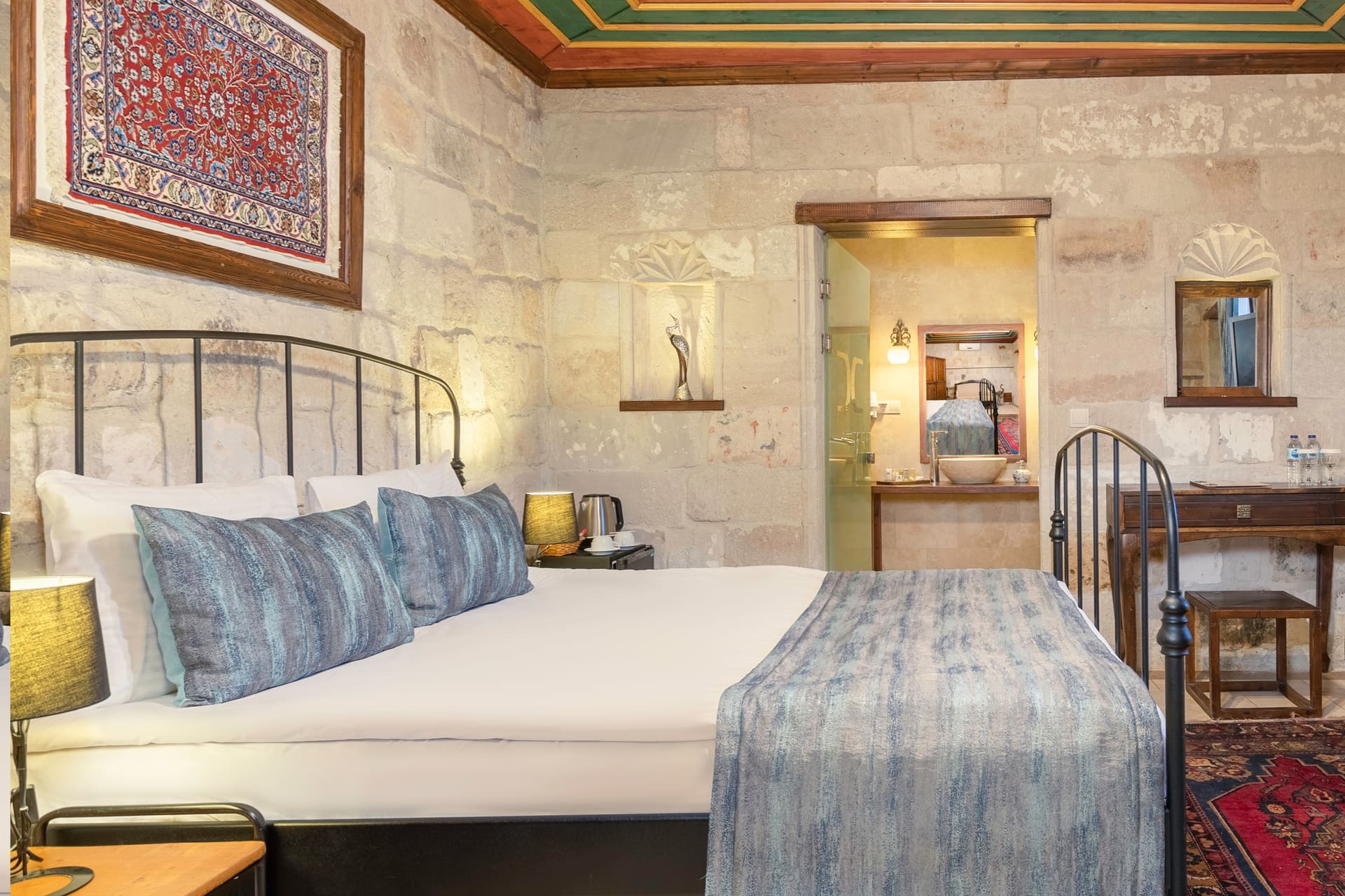 Room 101, Deluxe: Angled view of the bed, desk with a kettle, bathroom doorway