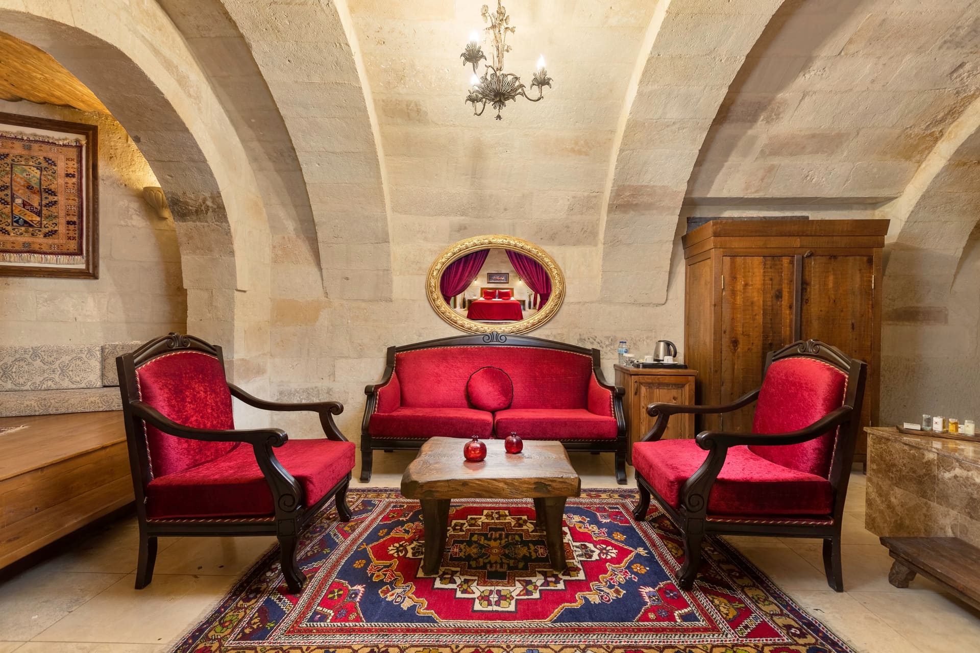 Room 110, Queen Suite: A sitting area with two red armchairs and a coffee table.