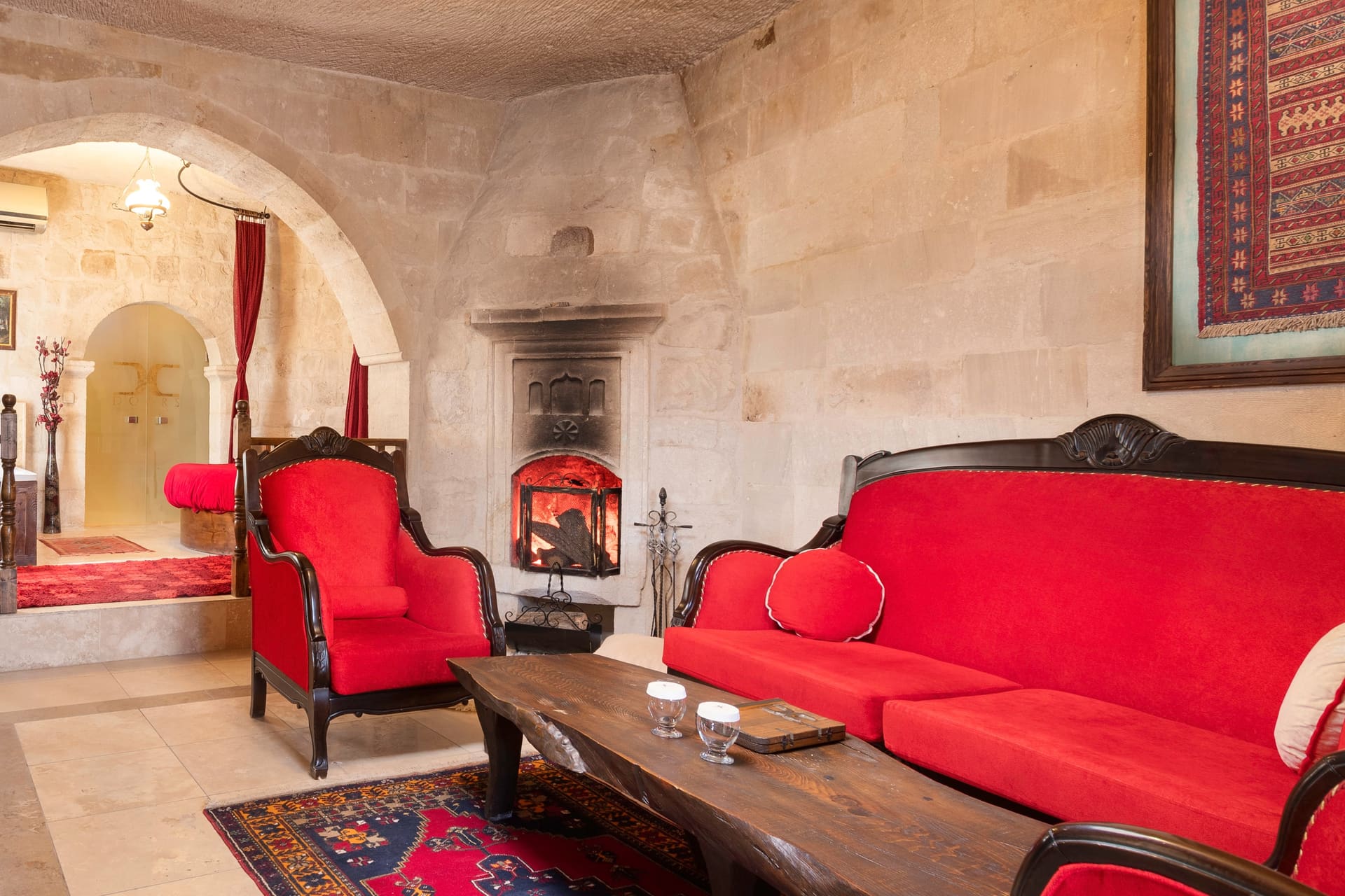 Room 107, King Suite: another angle of the sitting area with the red sofa and fireplace