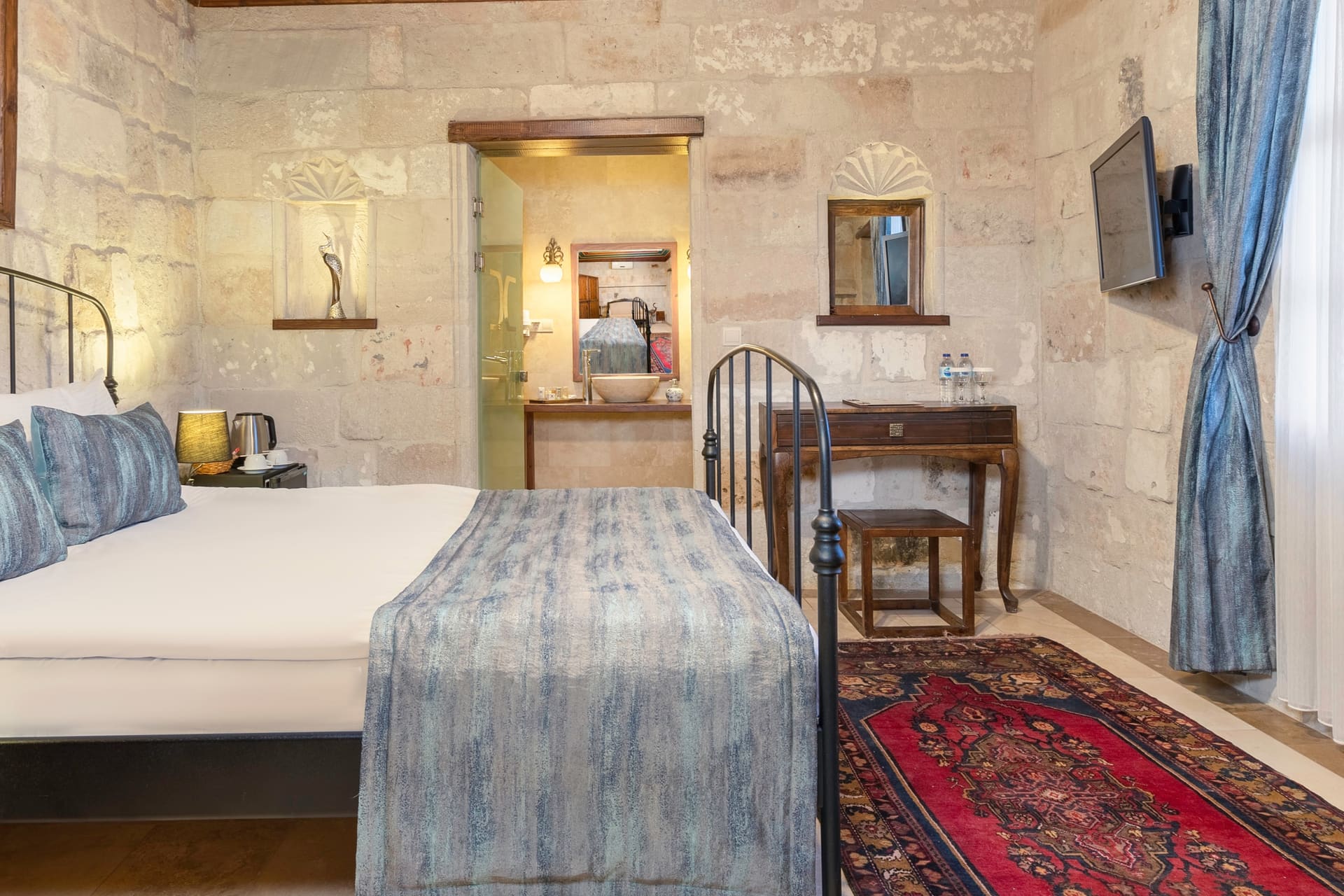 Room 101, Deluxe: Bed facing a television, mirror, bathroom entrance