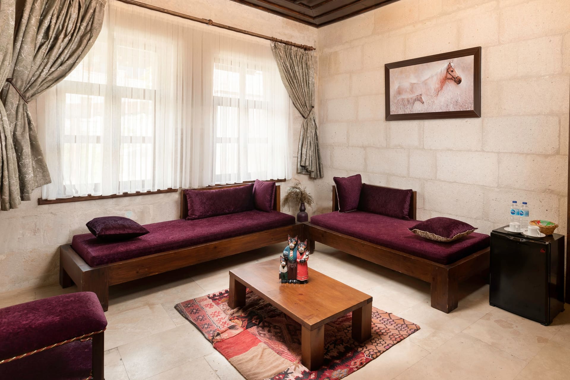 Room 117, Junior Suite: Purple sofas, coffee table, curtained windows, framed horse picture.