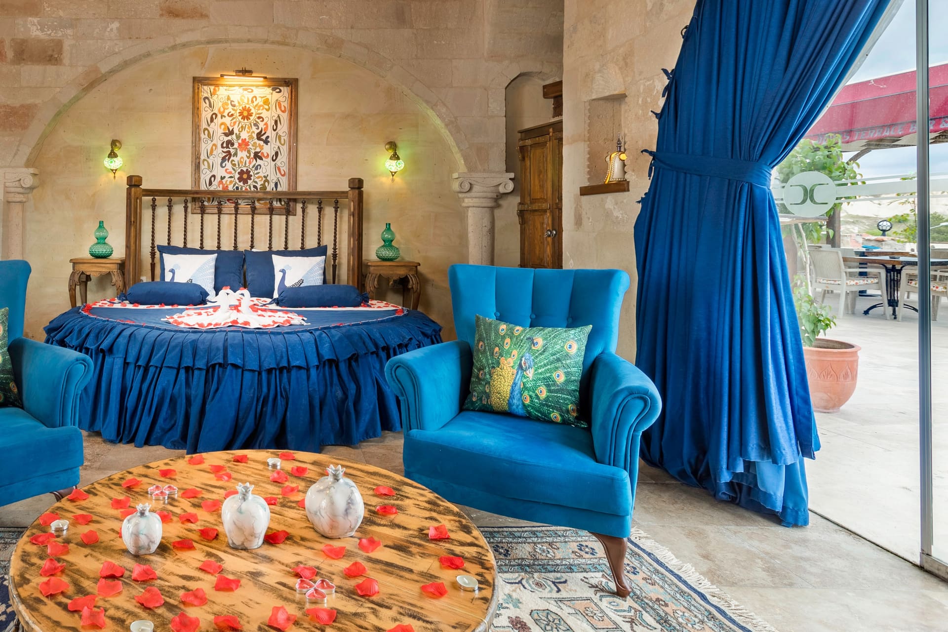 Room 120, Queen Suite: Round bed with the terrace visible through the open curtain.