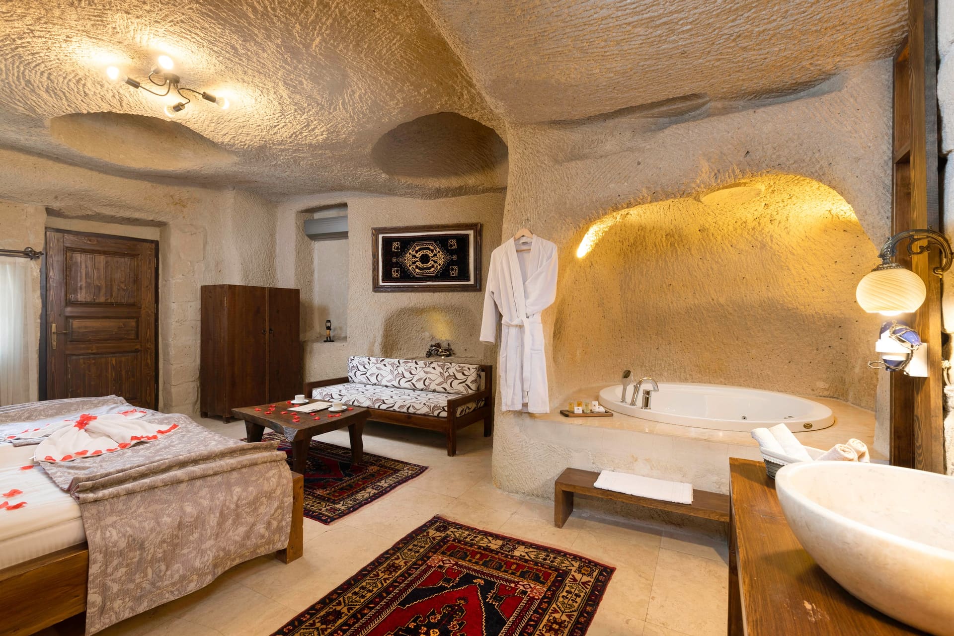 Room 113, Junior Cave Suite: wardrobe, rug, wooden door, rose petals on the bed