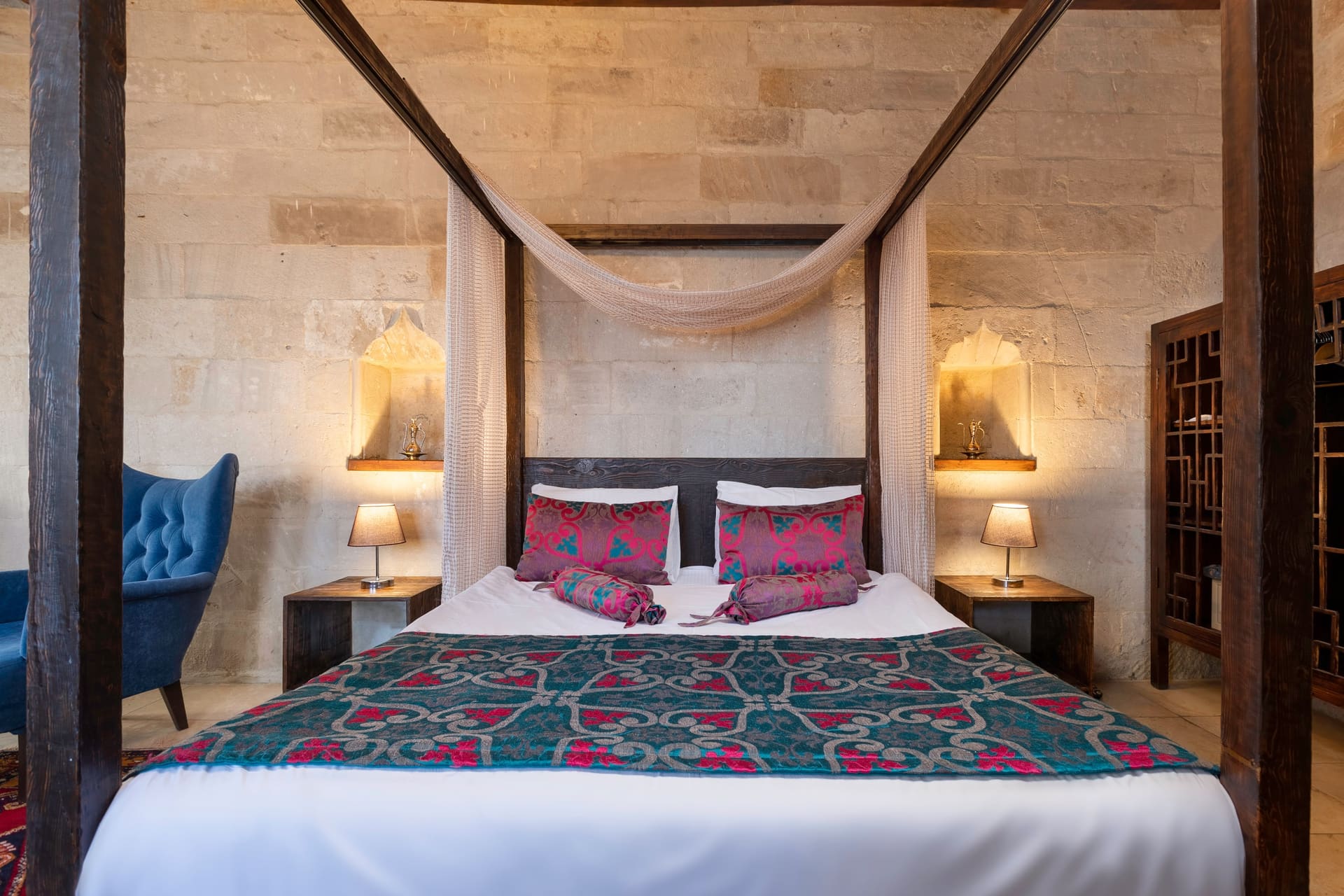 Room 102, Junior Suite: Close-up of headboard, patterned bedspread, lamps on both sides.
