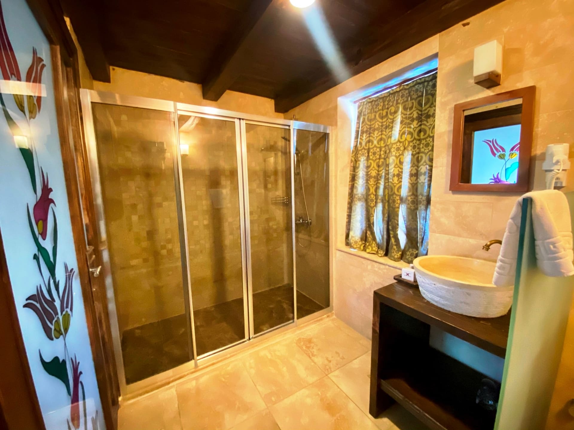 Room 104, Junior Suite: Bathroom, floral wall panel, glass shower, sink, mirror.