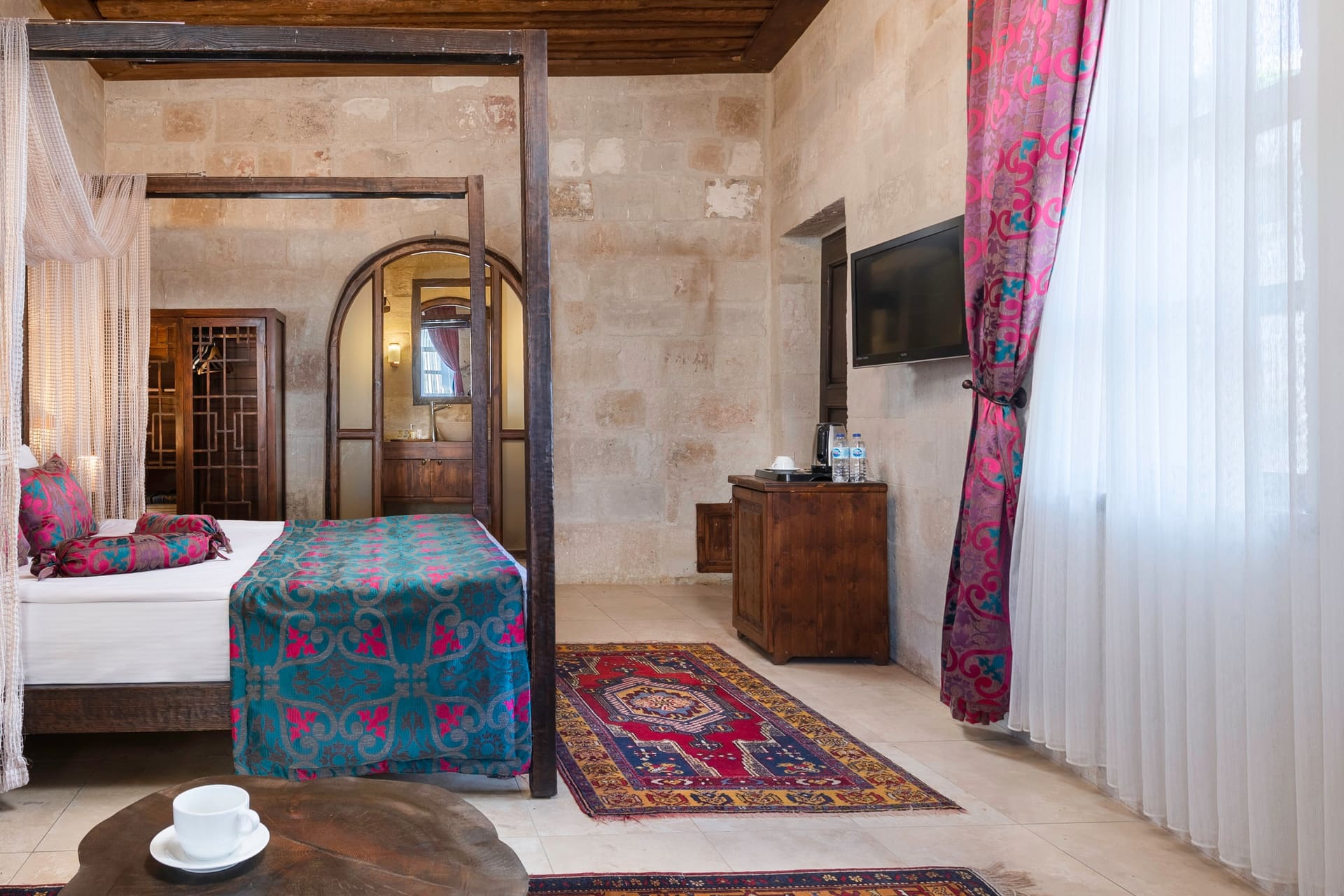 Room 102, Junior Suite: Single bed, arched door, wall-mounted TV, wood-beamed ceiling.