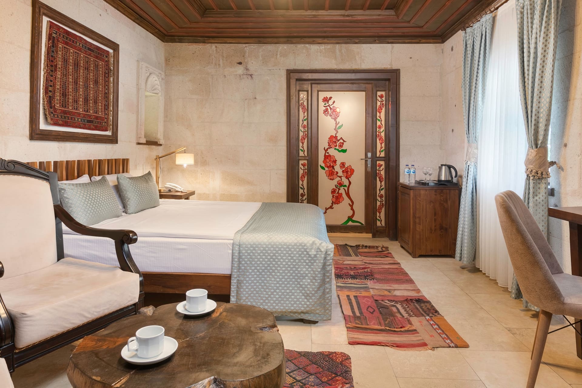 Room 116, Deluxe: Bed, seating nook, patterned glass door and curtains