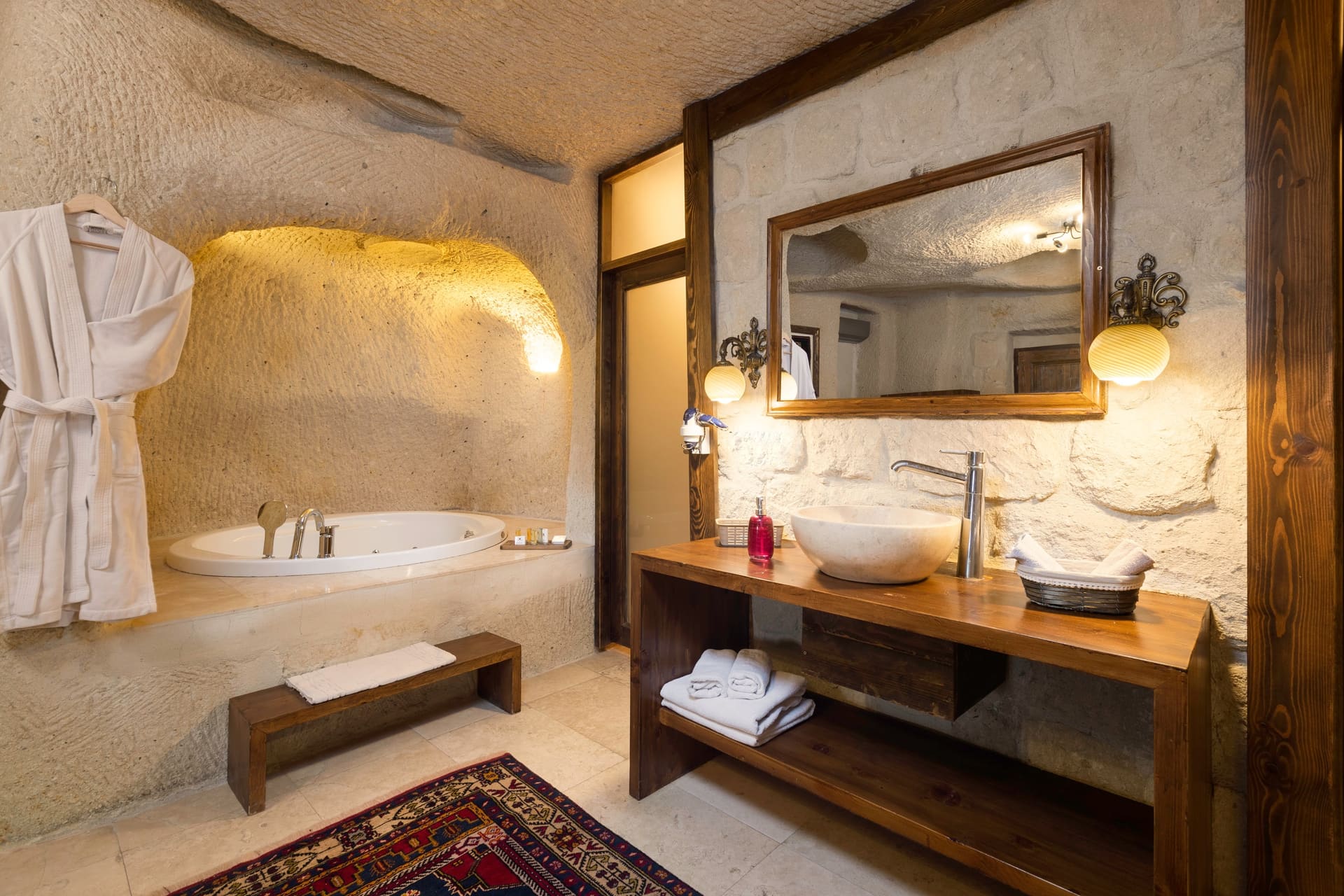 Room 113, Junior Cave Suite: bathroom sink counter, mirror, robe hanging on the wall