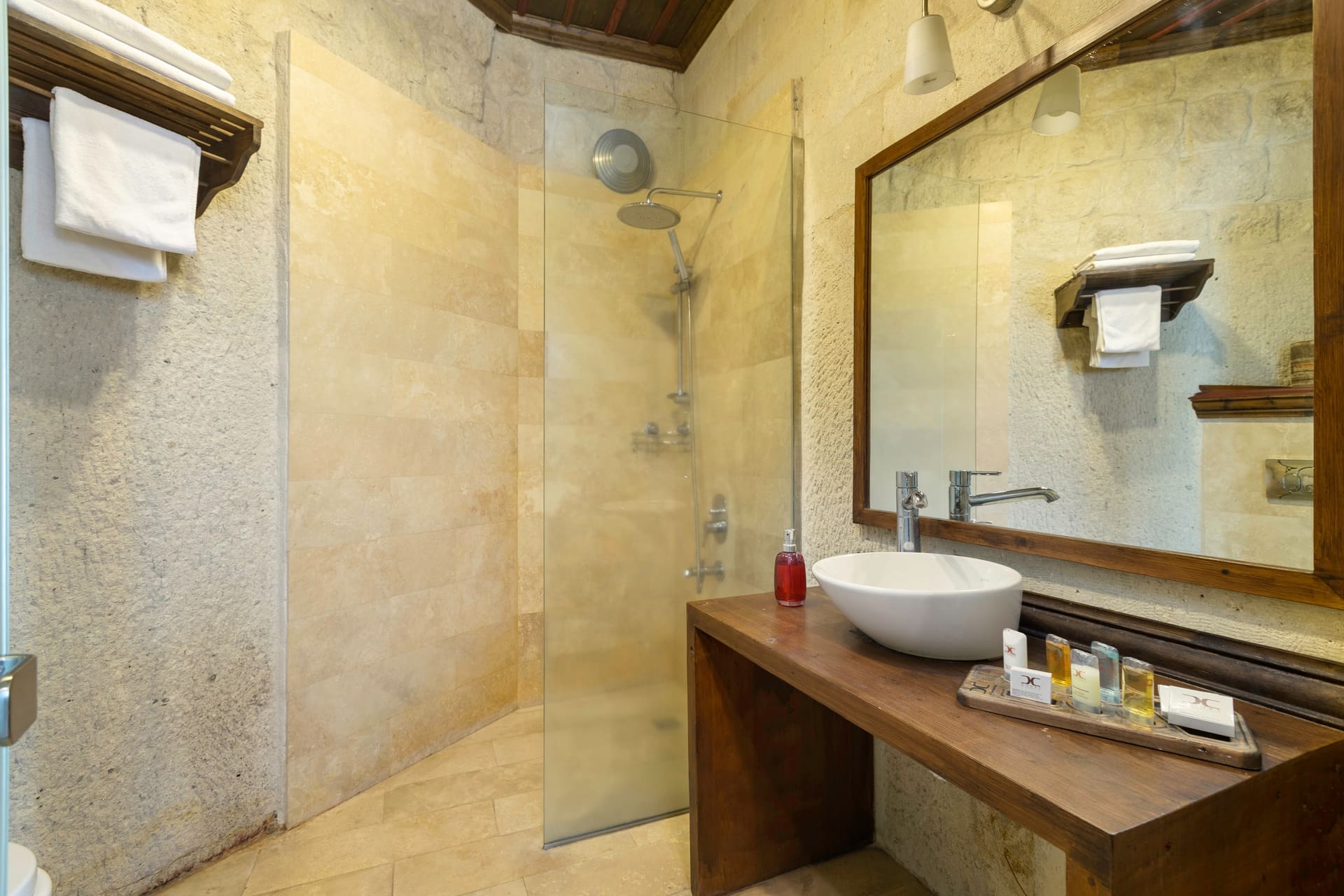 Room 109, Deluxe: Bathroom with shower, sink on a wooden counter, towels