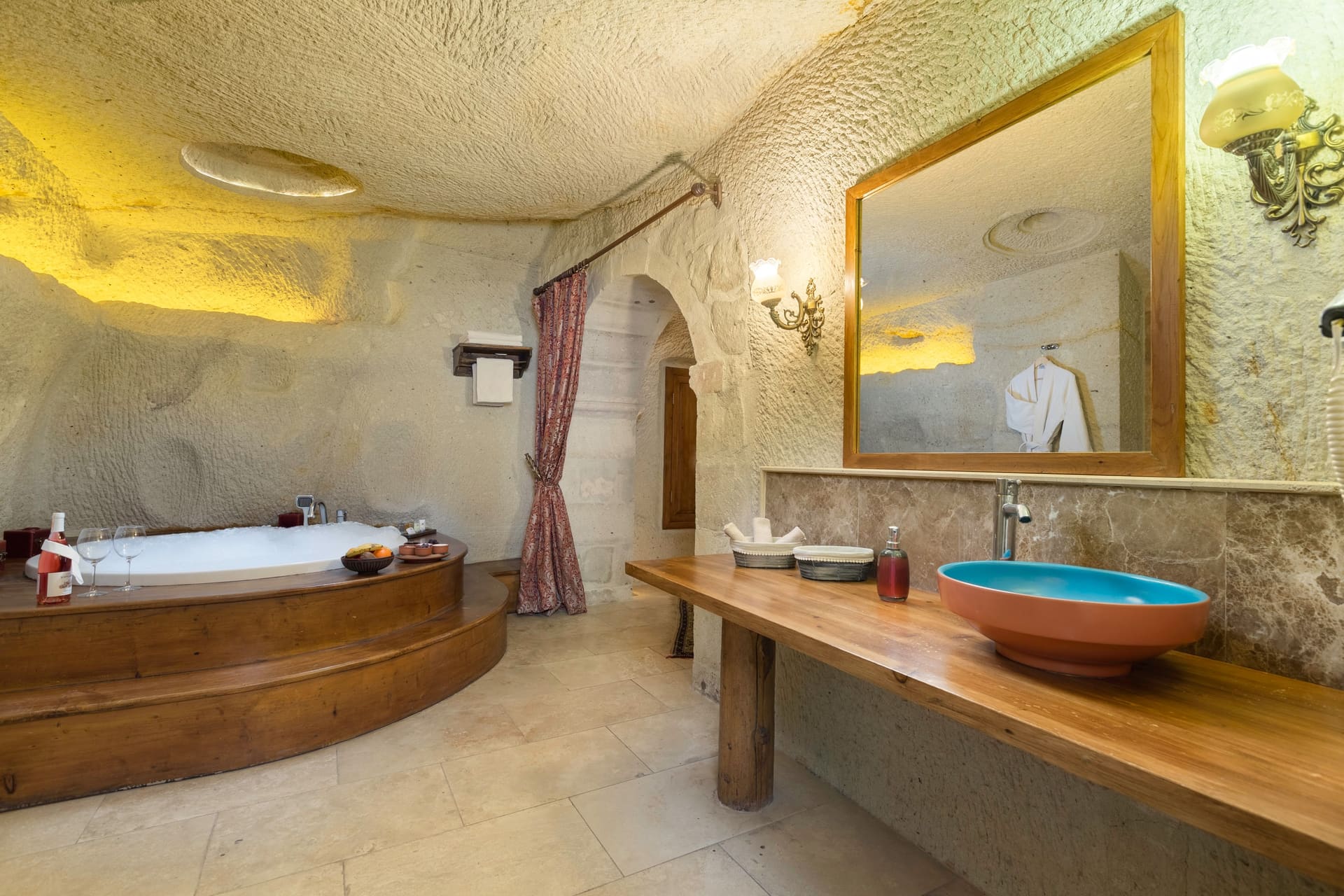 Room 112, King Cave Suite: the jacuzzi tub beside a wooden counter with a blue stone vessel sink