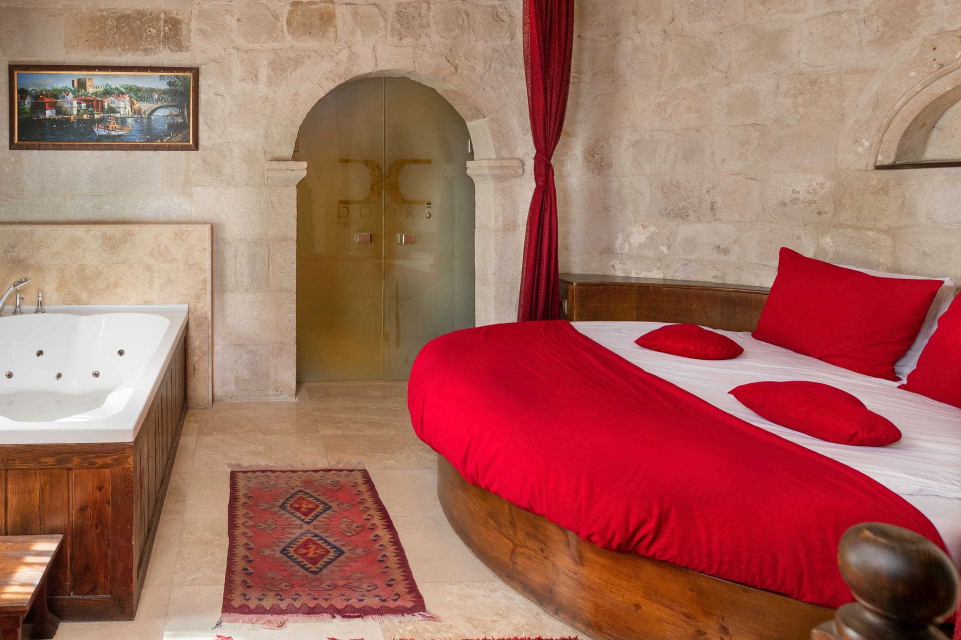 Room 107, King Suite: the jacuzzi tub, arched doors and the round red bed