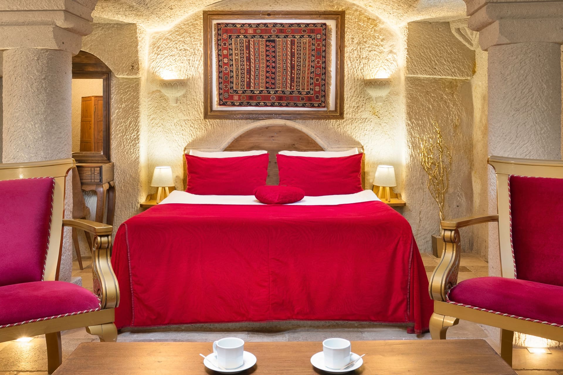 Room 115, Junior Cave Suite: burgundy bedspread, bolster pillow, vaulted stone ceiling