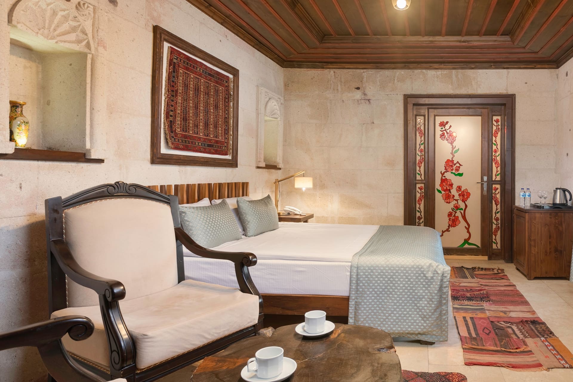 Room 116, Deluxe: Bed, armchair and coffee table seating area, arched doorway