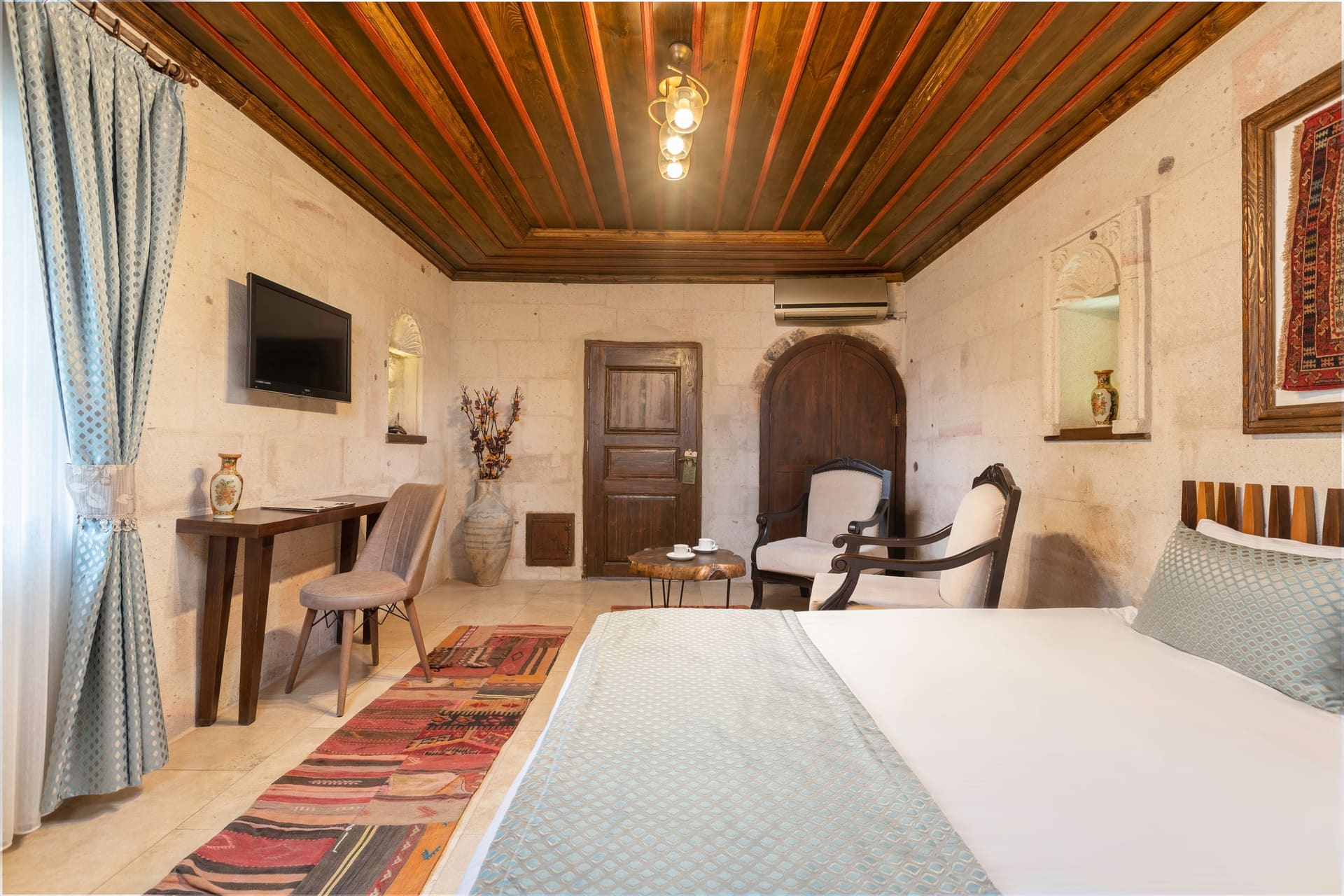 Room 116, Deluxe: View from the bed toward the door, wooden beam ceiling, desk