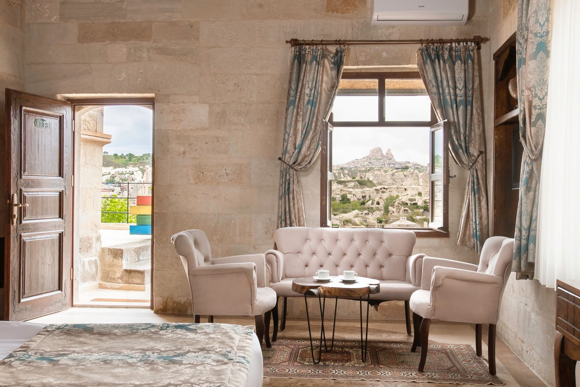 Room 103, Deluxe: Open terrace door showing the valley and rock formation view, curtains