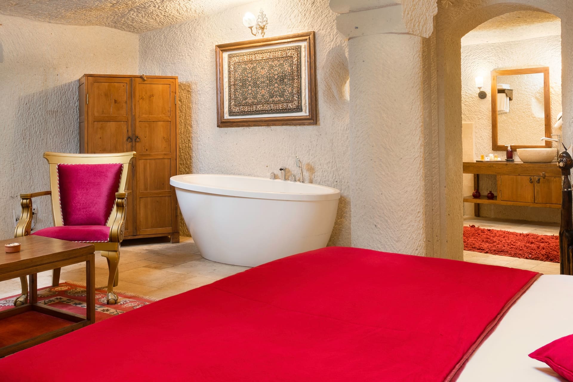 Room 115, Junior Cave Suite: bed and wardrobe, bathtub, mirror, burgundy chairs