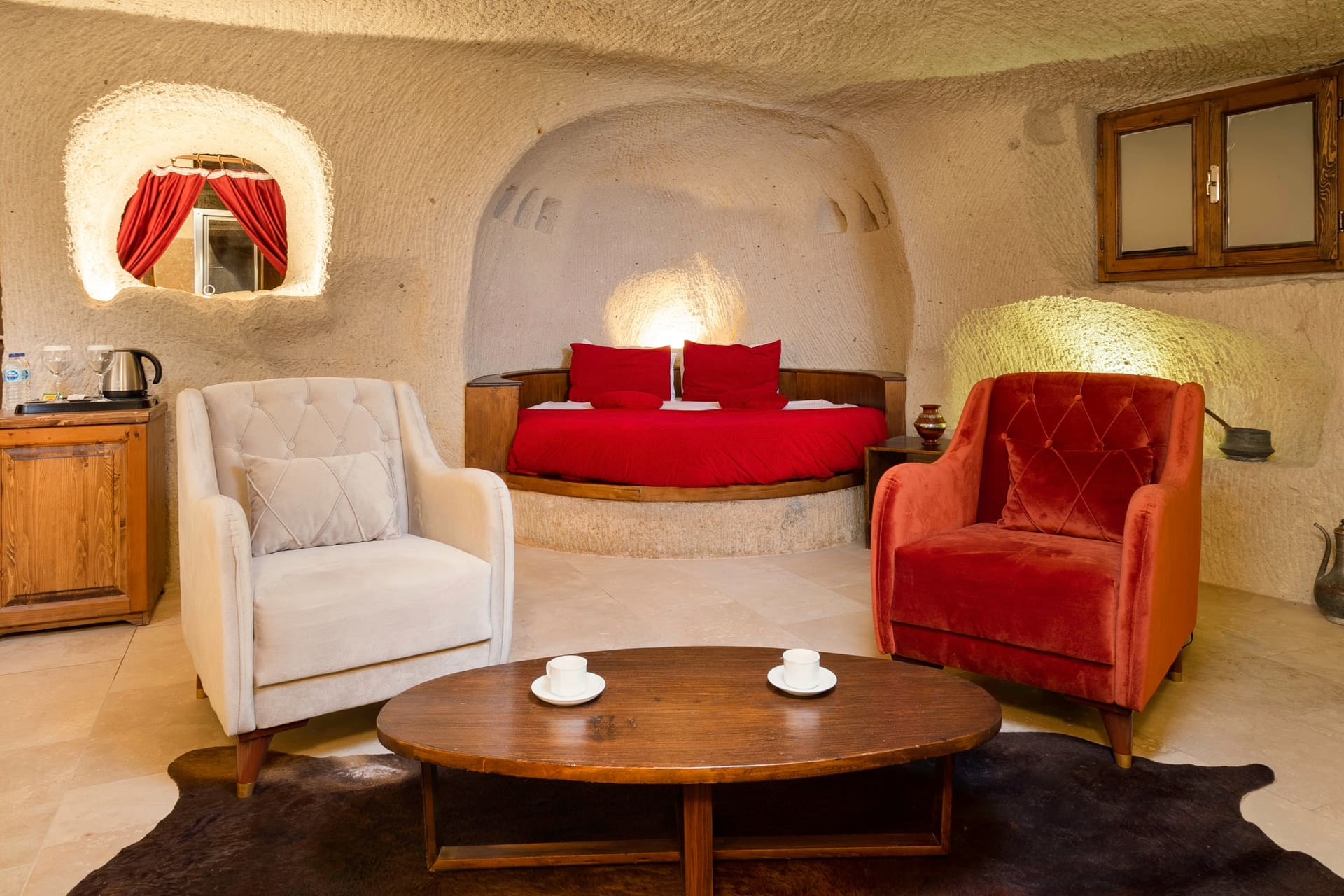 Room 106, King Cave Suite: a window-side niche with a red curtain, the bed, armchairs and round table