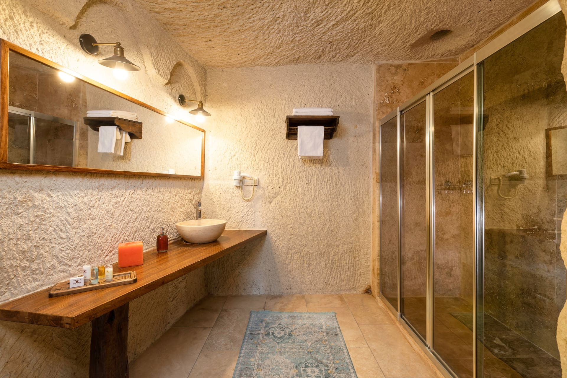 Room 114, Junior Cave Suite: bathroom sink, mirror, glass shower stall, wardrobe
