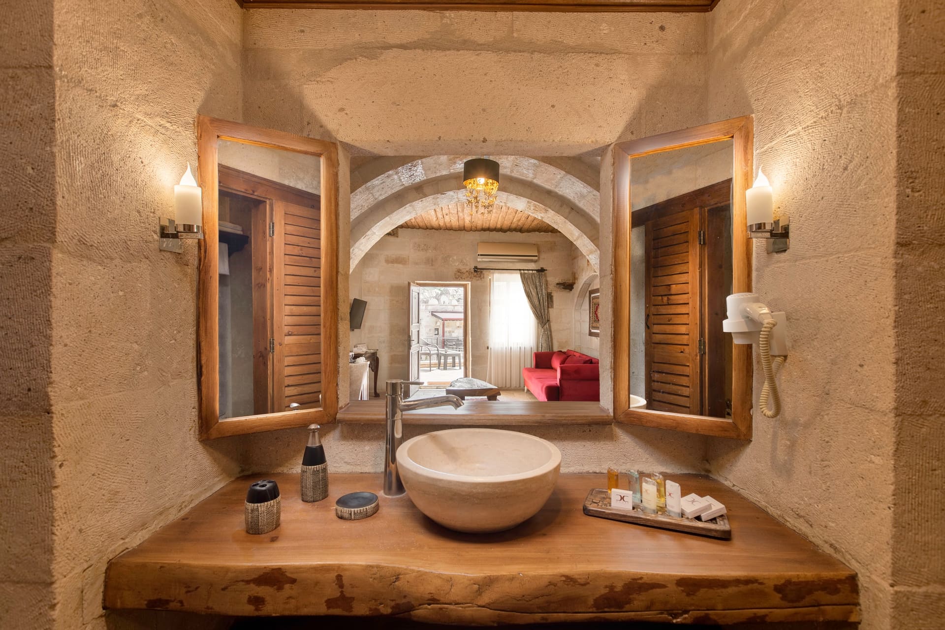 Room 108, Junior Suite: Bathroom, vessel sink on wood counter, mirror, shuttered window, toiletries.