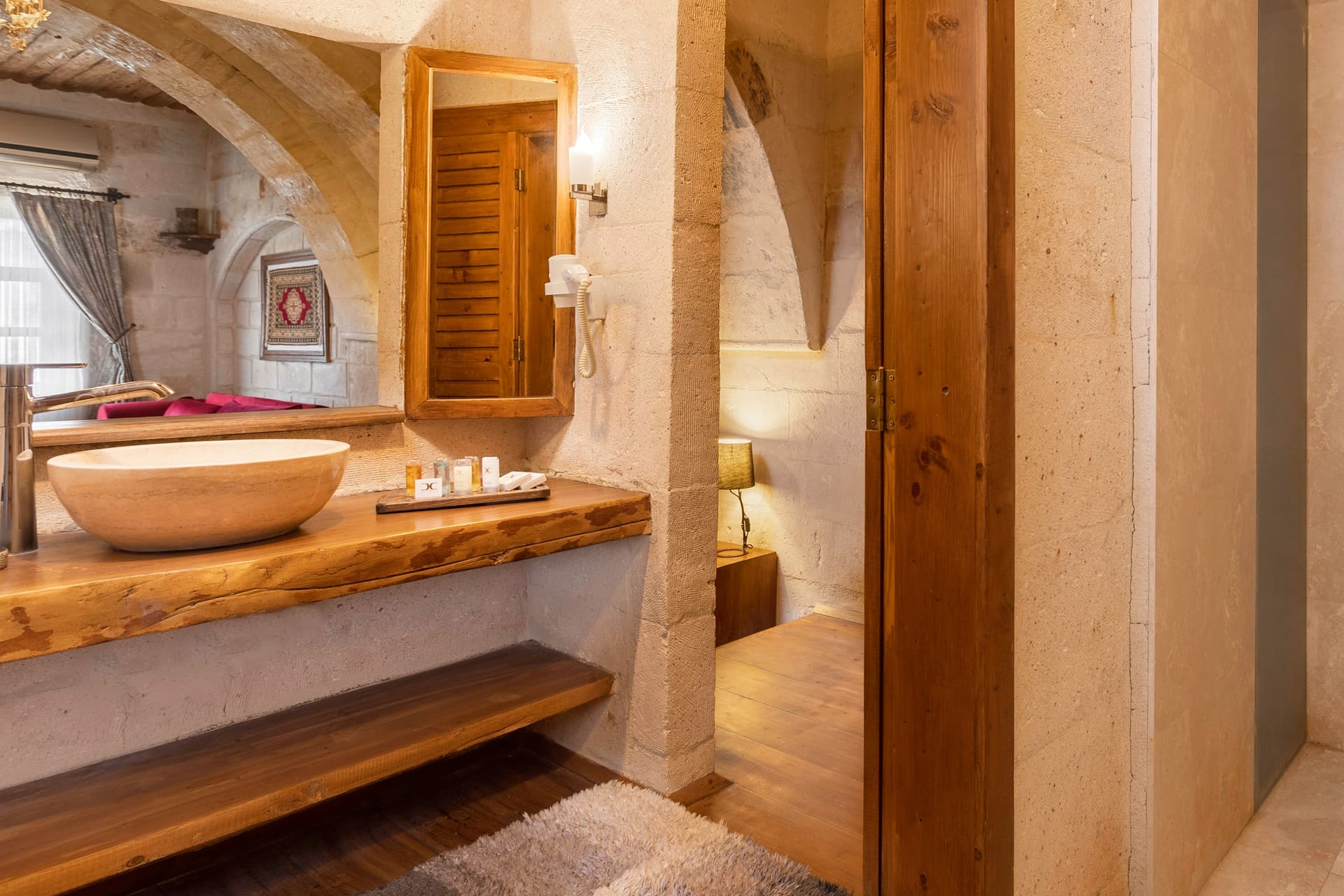 Room 108, Junior Suite: Bathroom counter, sink, wooden shelf, wardrobe door, rug.