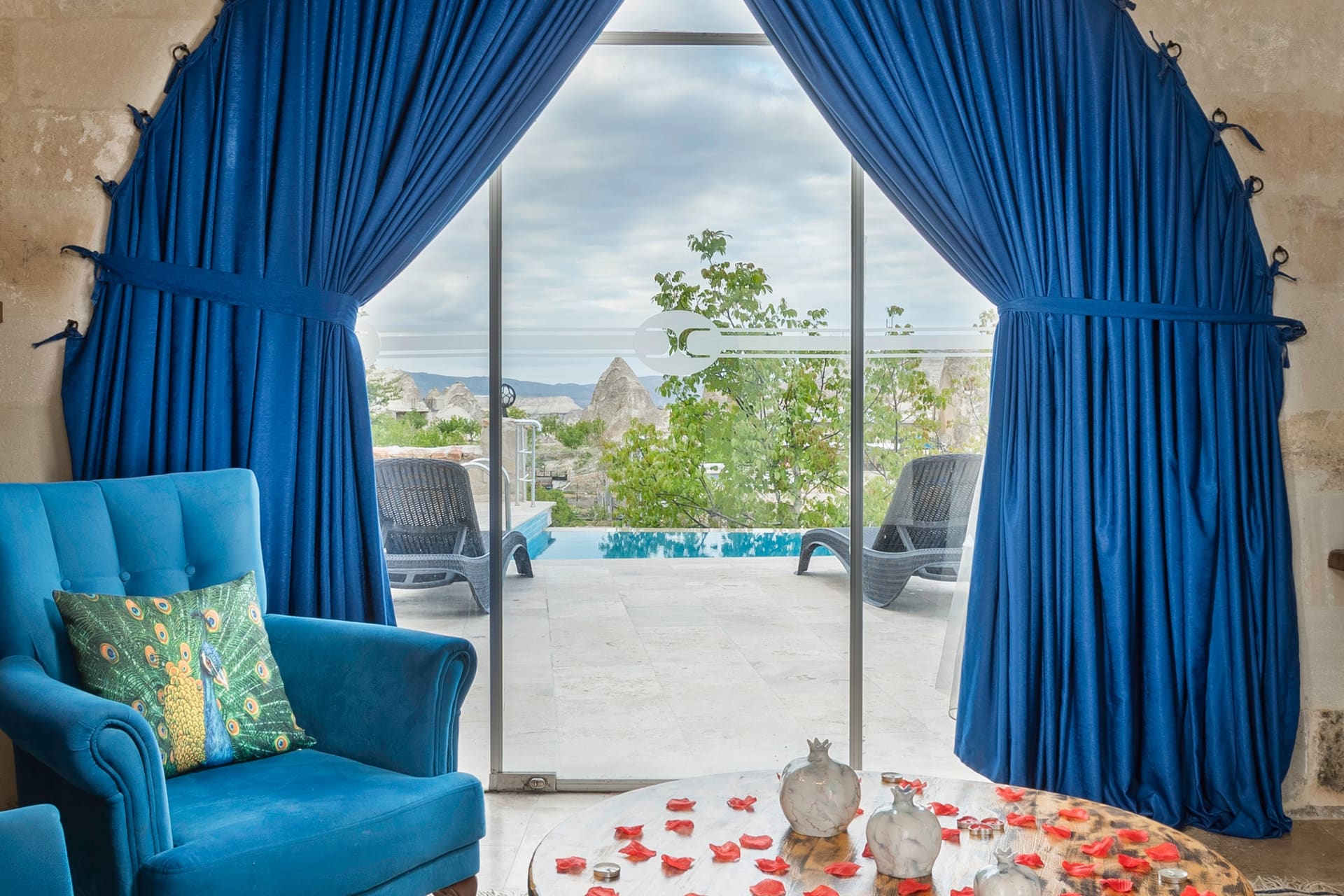 Room 120, Queen Suite: TV and a blue armchair, with the arched terrace door behind.