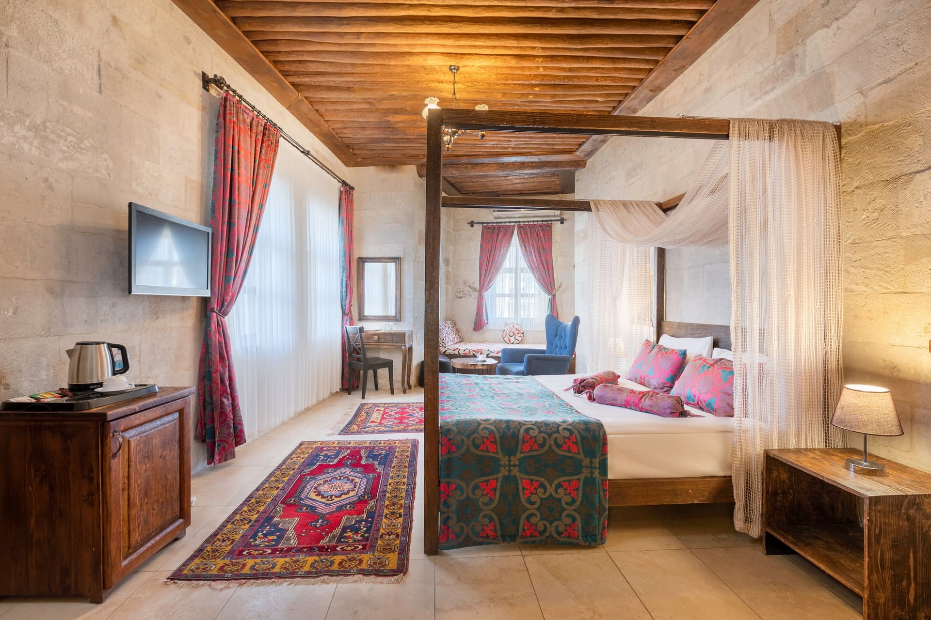 Room 102, Junior Suite: Four-poster canopy bed, wall-mounted TV, curtained window.