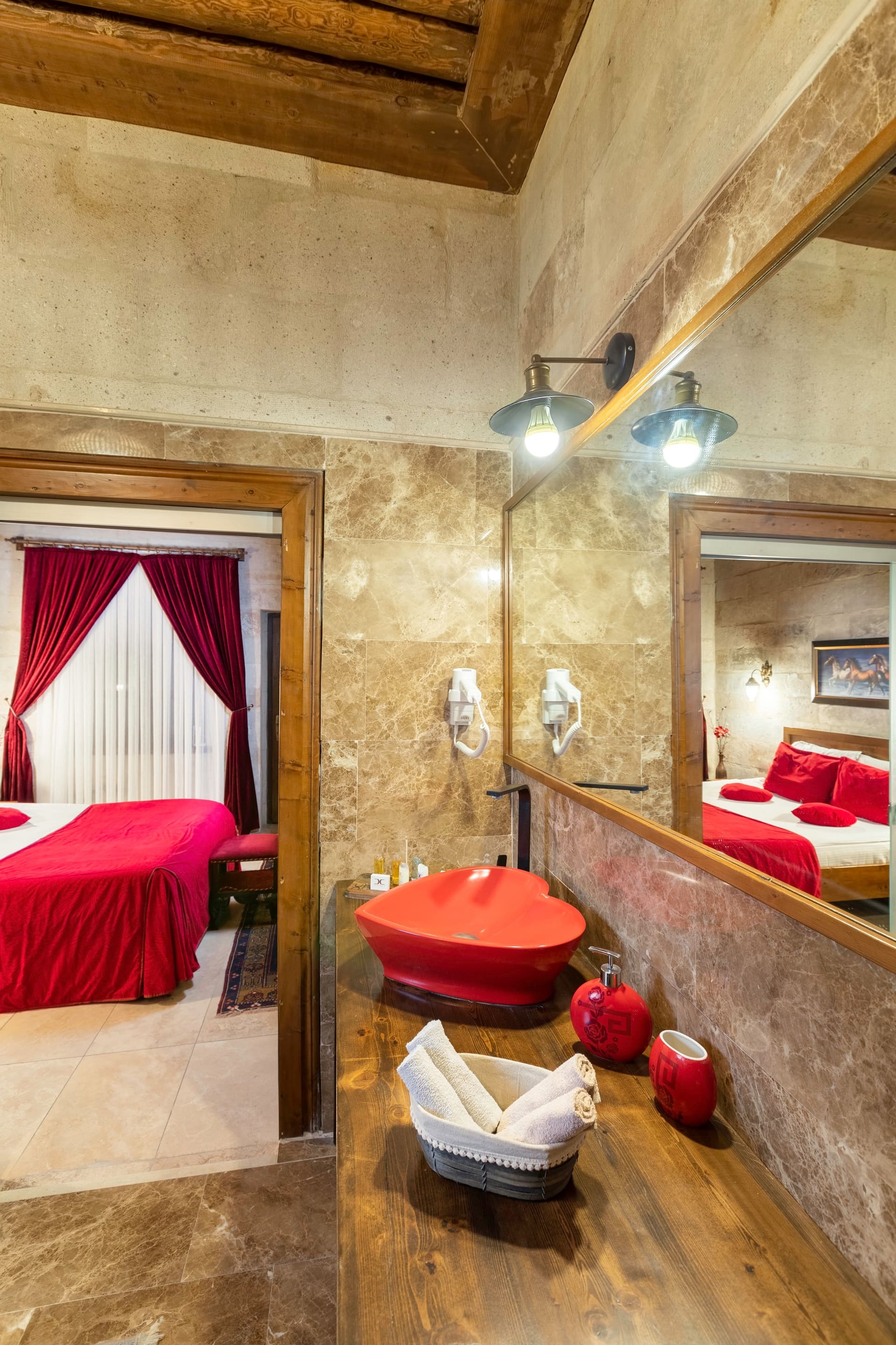 Room 110, Queen Suite: A lit stone passage with the bed and a decorative vase beyond.