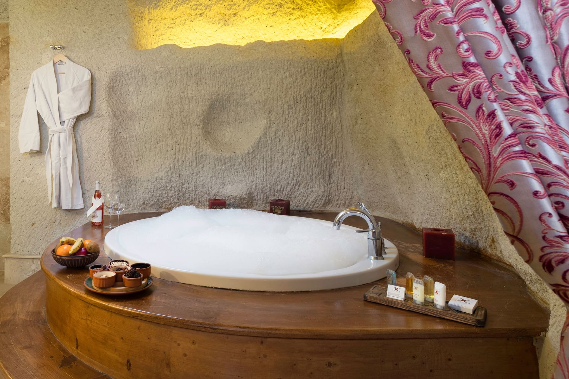 Room 112, King Cave Suite: close-up of the jacuzzi tub, a robe hanging, and a floral curtain