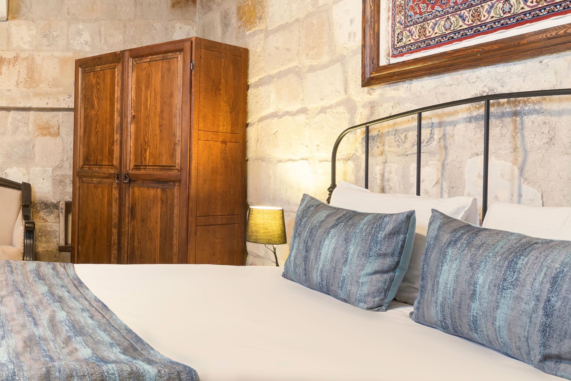 Room 101, Deluxe: Close view of the headboard with framed artwork above, wooden wardrobe