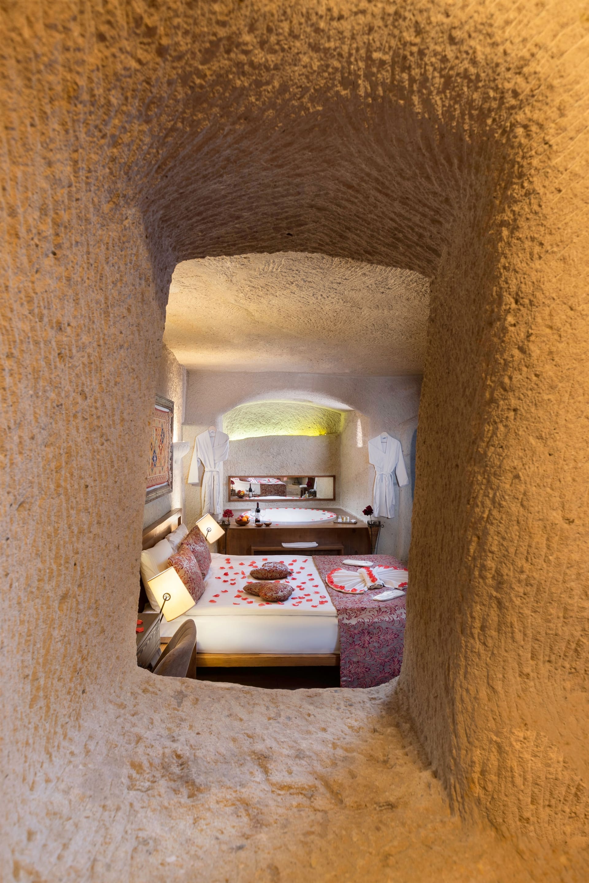 Room 111, King Cave Suite: a stone tunnel corridor leading to the arched opening into the bedroom