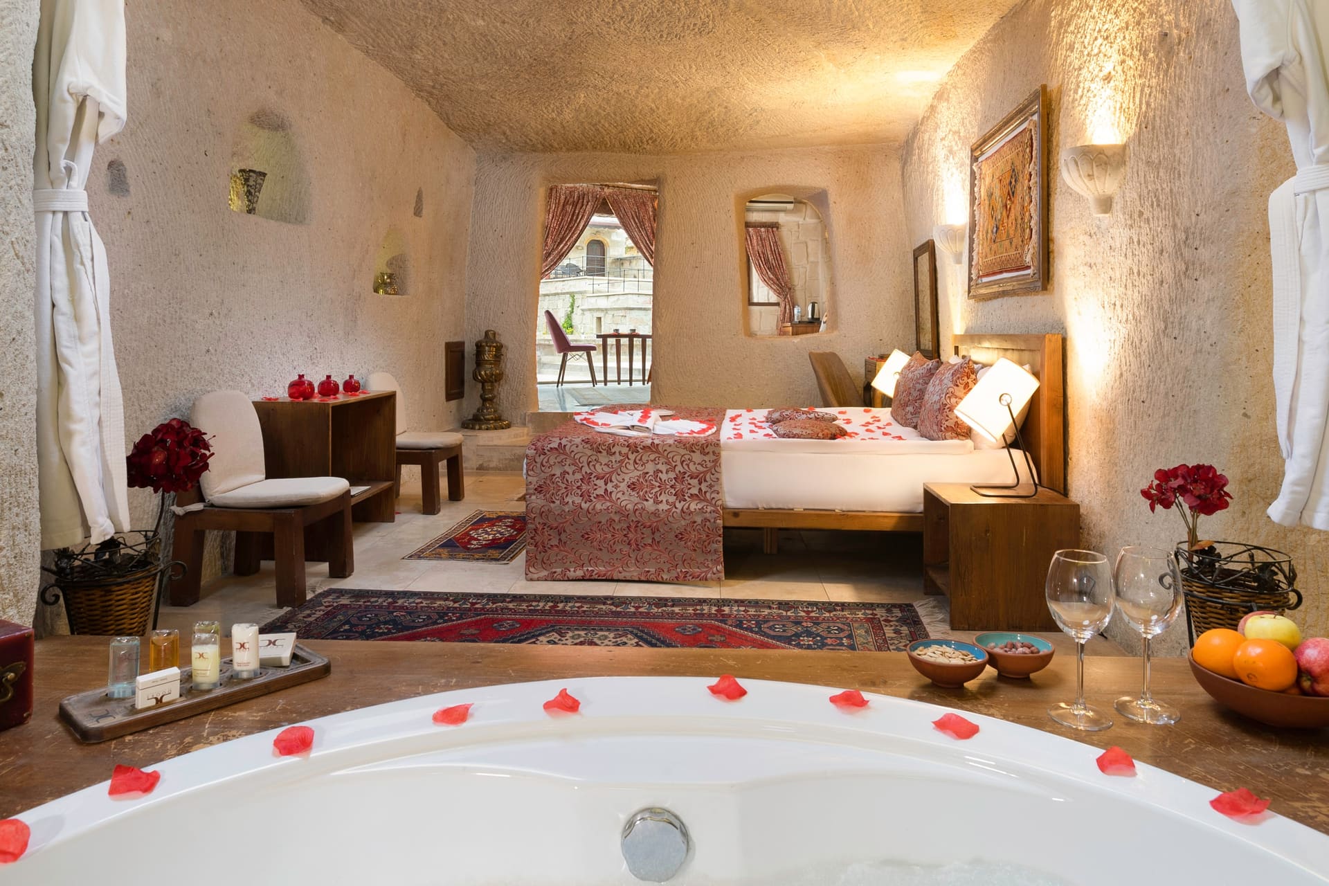 Room 111, King Cave Suite: another angle of the bed and terrace doorway, a mirrored console on the left
