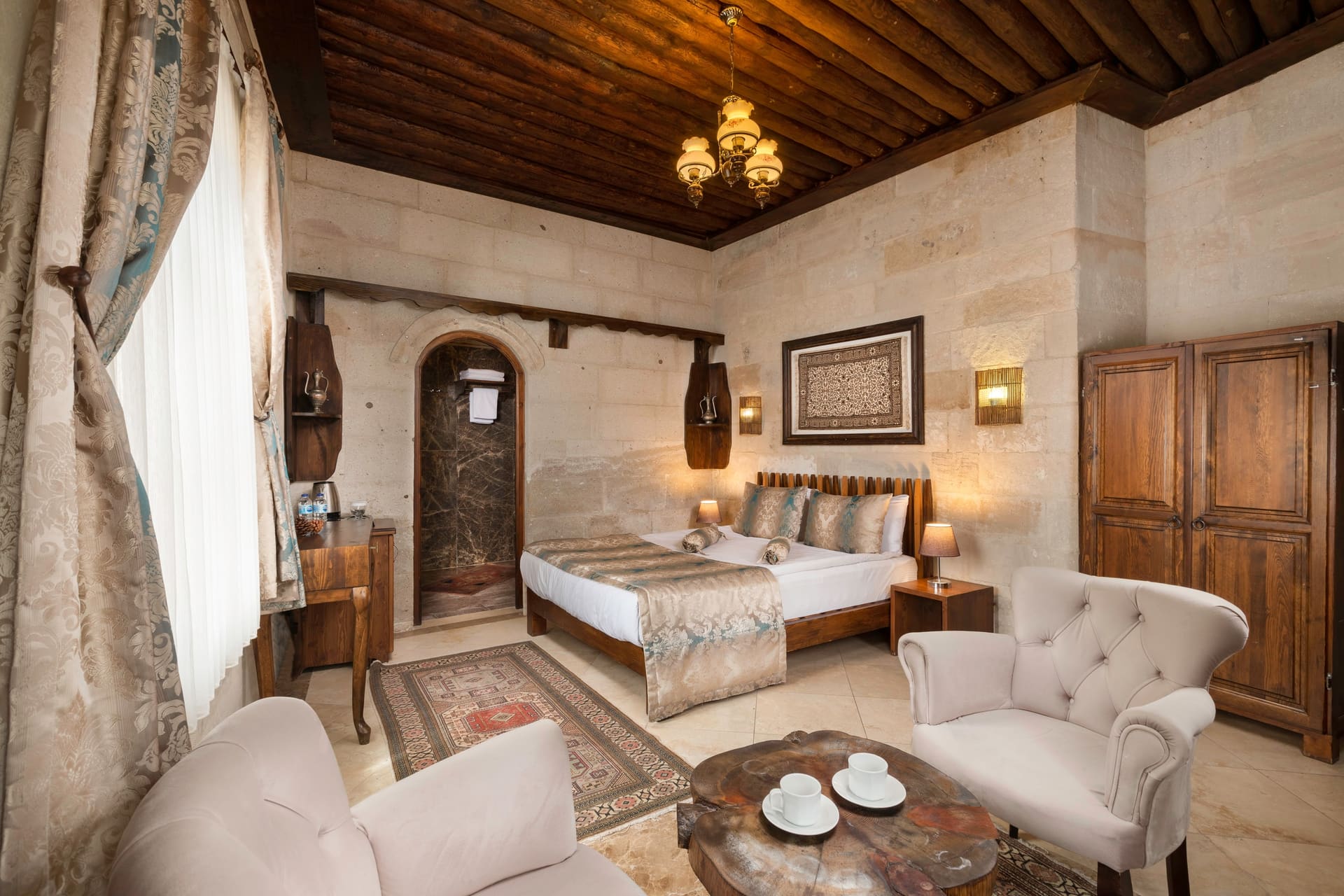 Room 103, Deluxe: Wide view of the room, bed and a seating group with a round table