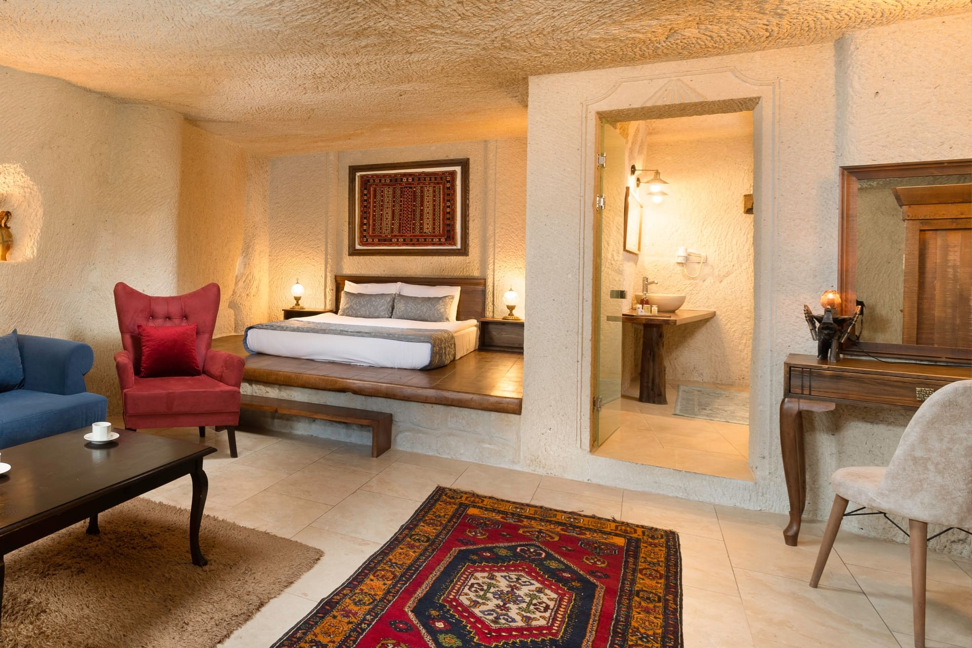 Room 114, Junior Cave Suite: burgundy armchair, bed alcove, sink visible through the doorway