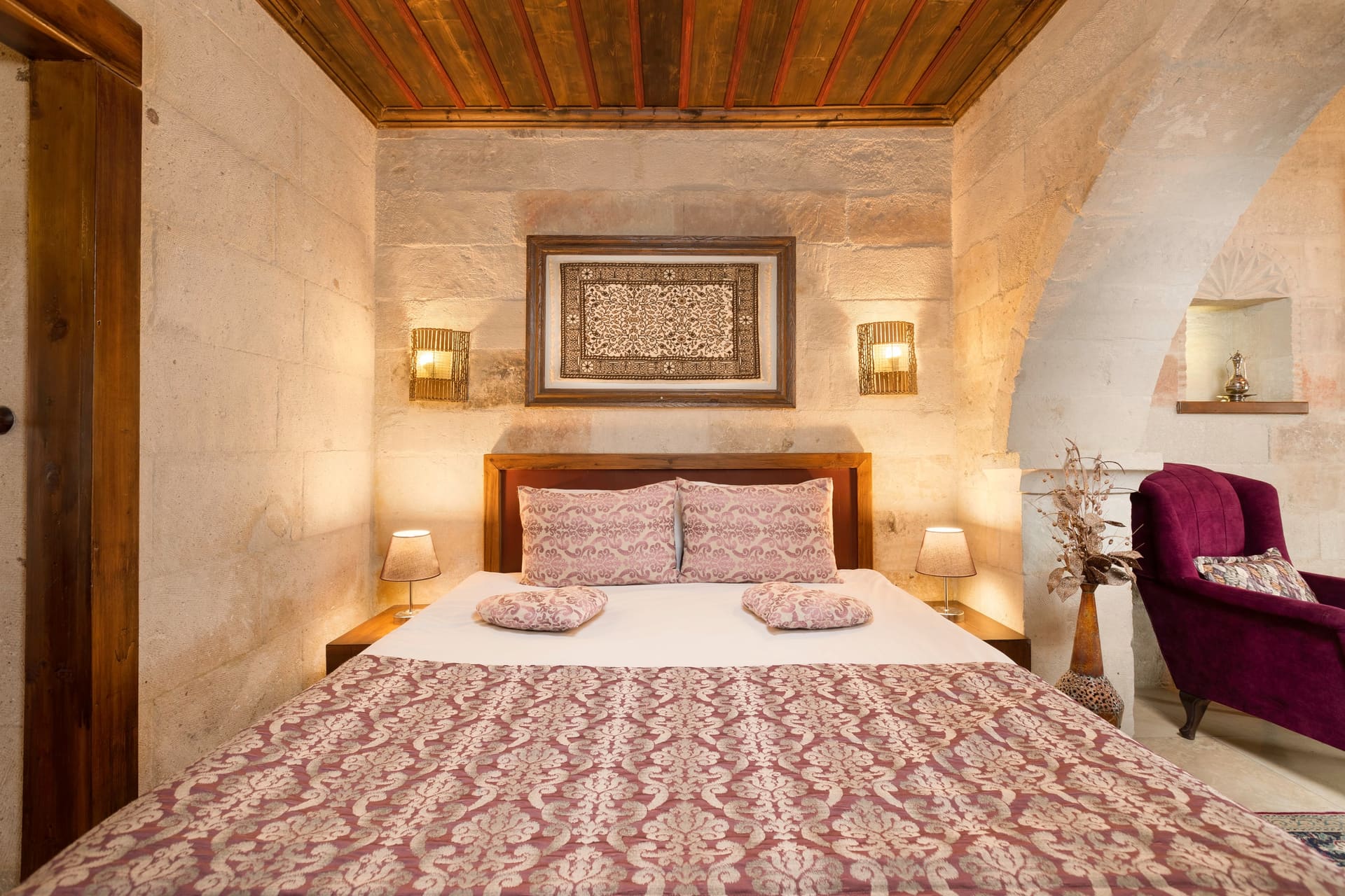 Room 105, King Suite: another close angle of the headboard with the wall decoration and sconces