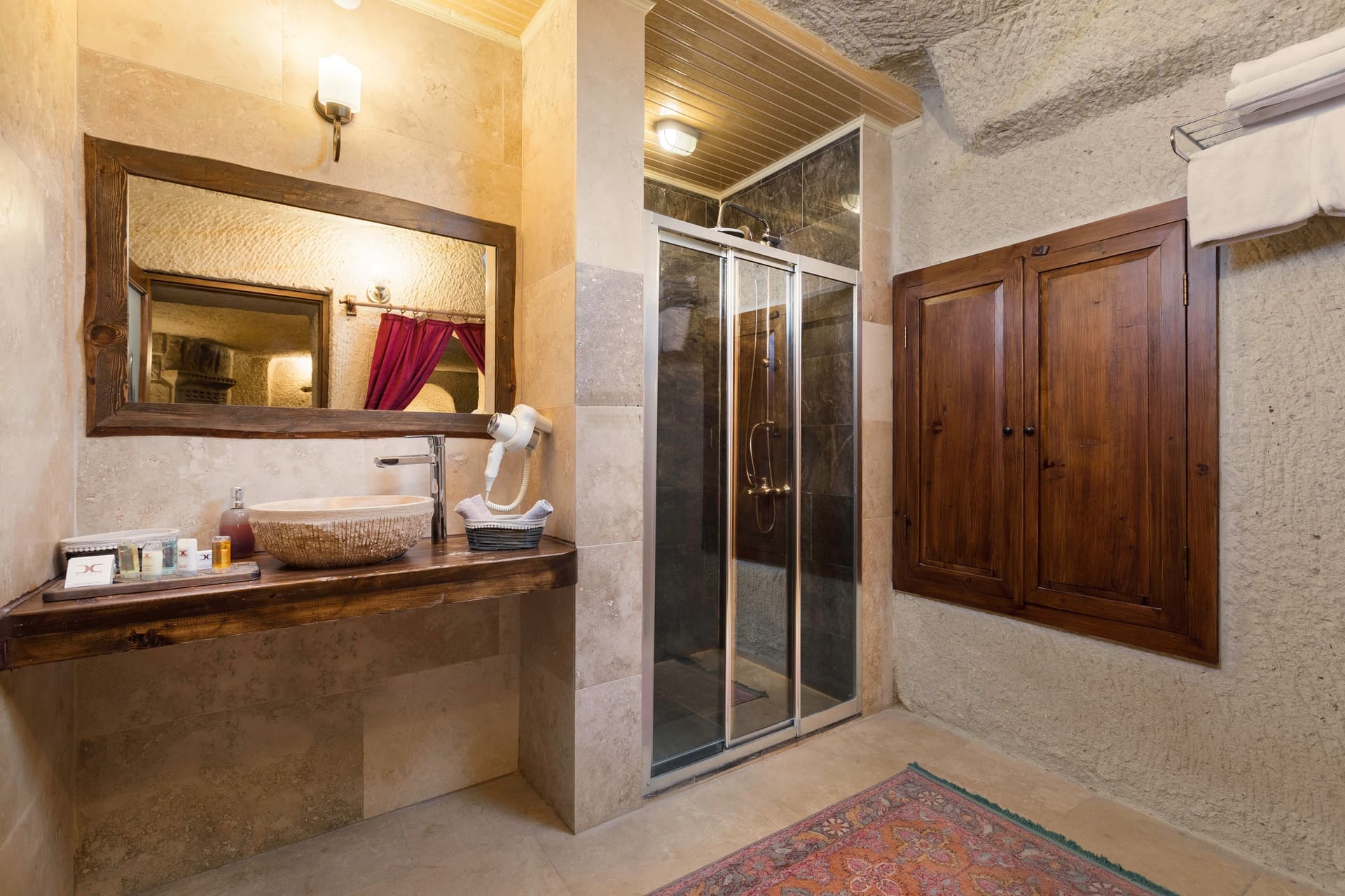Room 106, King Cave Suite: bathroom with a stone vessel sink, a mirrored cabinet, and a glass shower stall