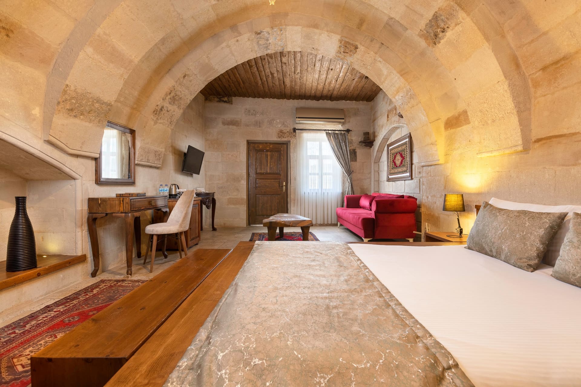 Room 108, Junior Suite: Wide view of bed, desk and chairs in background, arched ceiling.